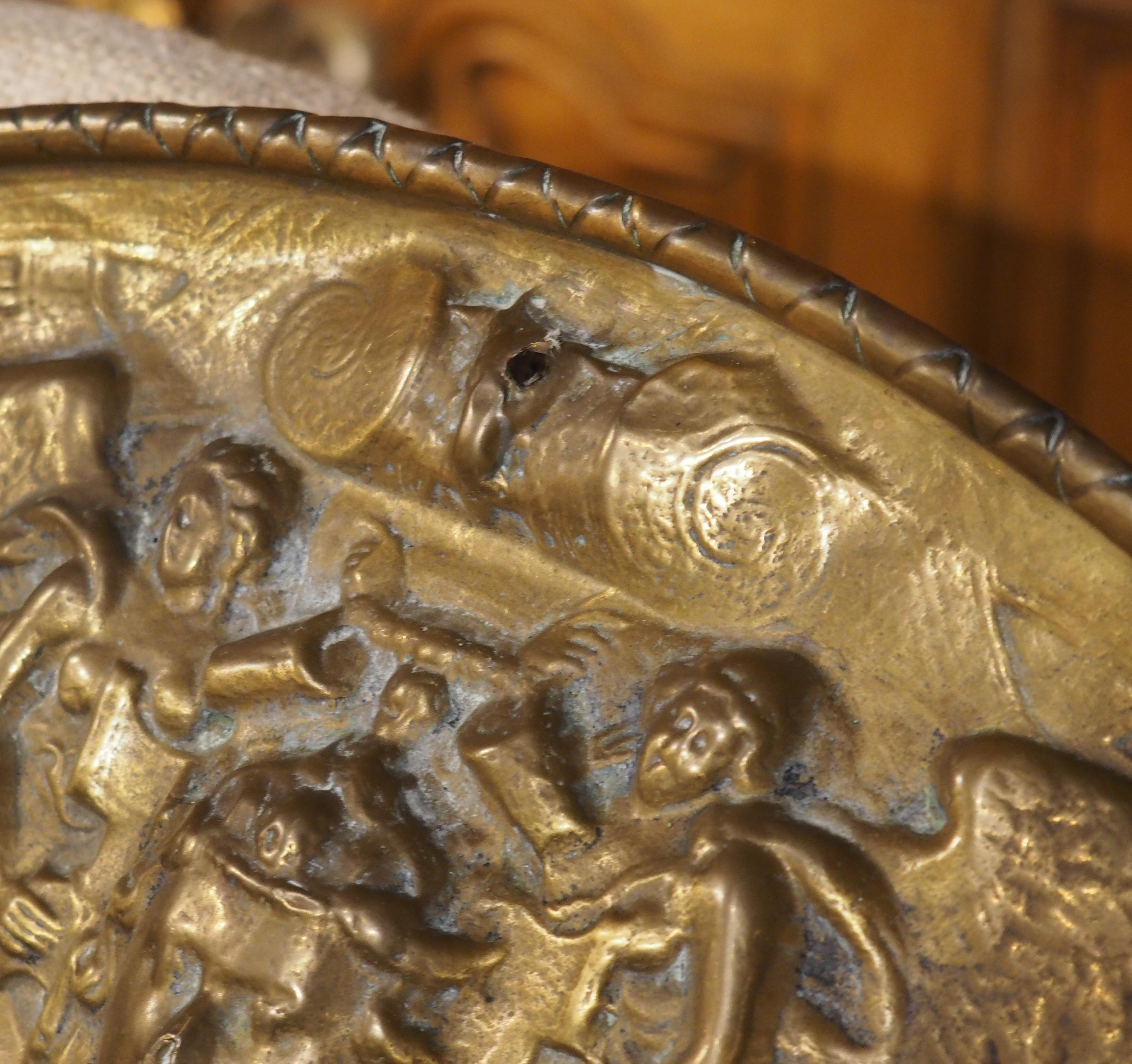 Progettato per essere esposto in modo decorativo nelle parate del XIX secolo, questo scudo francese è stato lavorato a mano in stile repousse, ovvero la scena è martellata dal lato del verso, dando profondità alle immagini. Basato sullo scudo