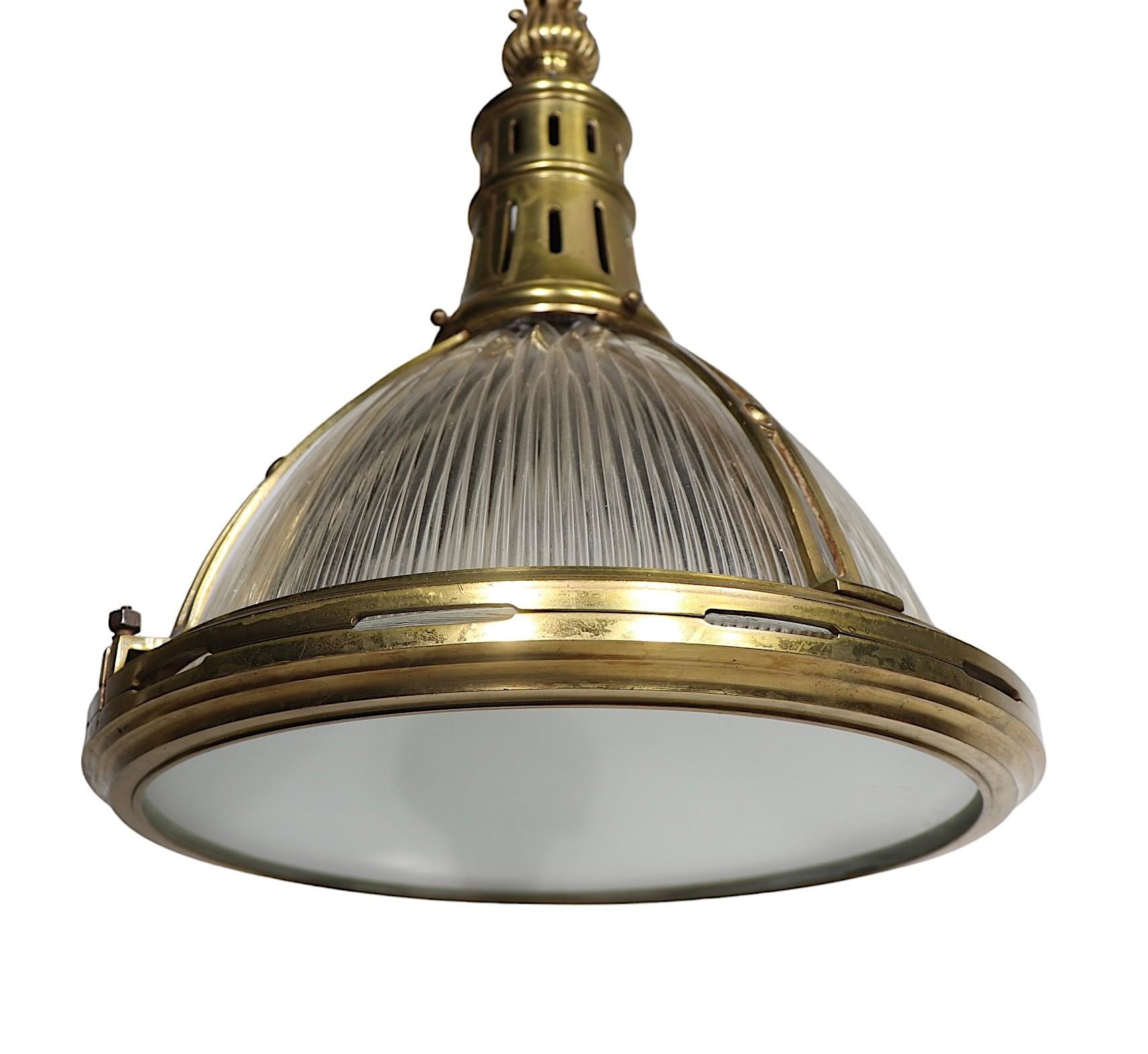 Exceptional Halophane  pendant fixture featuring a decorative cast brass frame, with swing open glass bottom diffuser shade, and classic Halophane ribbed glass shade. The chandelier  is in very fine, working, clean and ready to install condition,