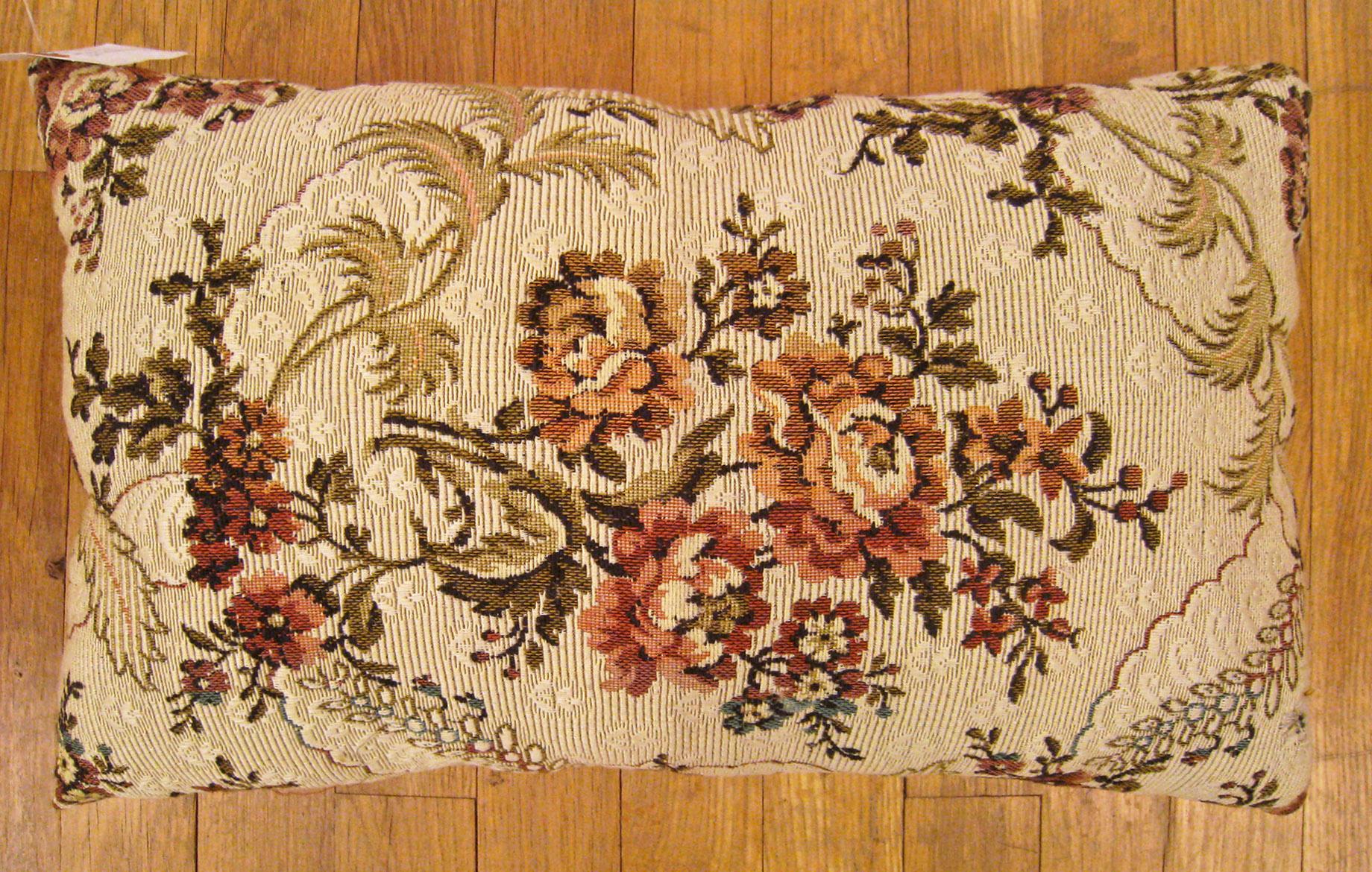 Antique Jacquard Tapestry pillow; size 1'0” x 1'8”.

An antique decorative pillow with floral elements allover an ivory central field, size 1'0