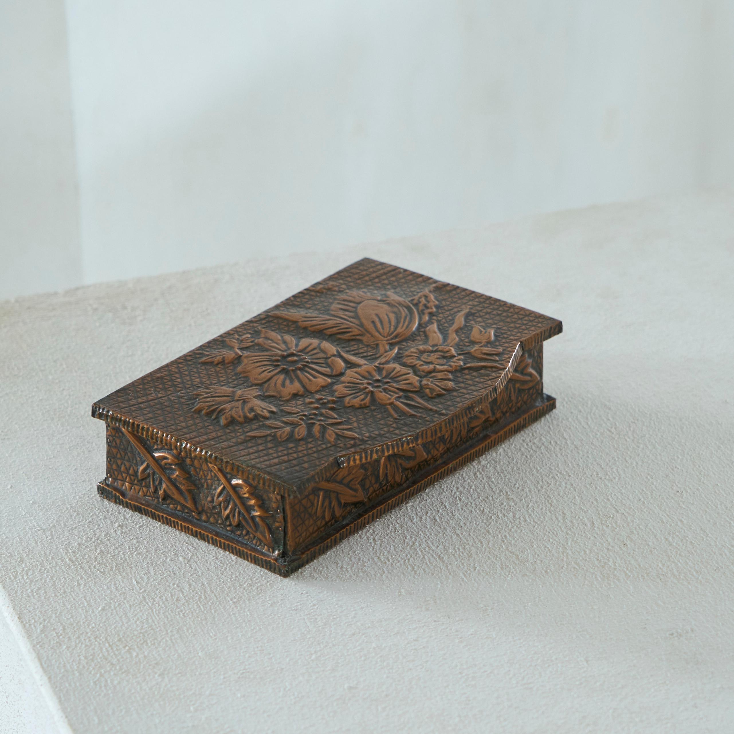 Decorative Art Deco Box in Hand Hammered Copper 1930s.

A wonderful hand made decorative box in hand hammered copper. Features intricate patterns and shapes and floral decorations on all sides. Lined with a floral fabric inside. A great piece of