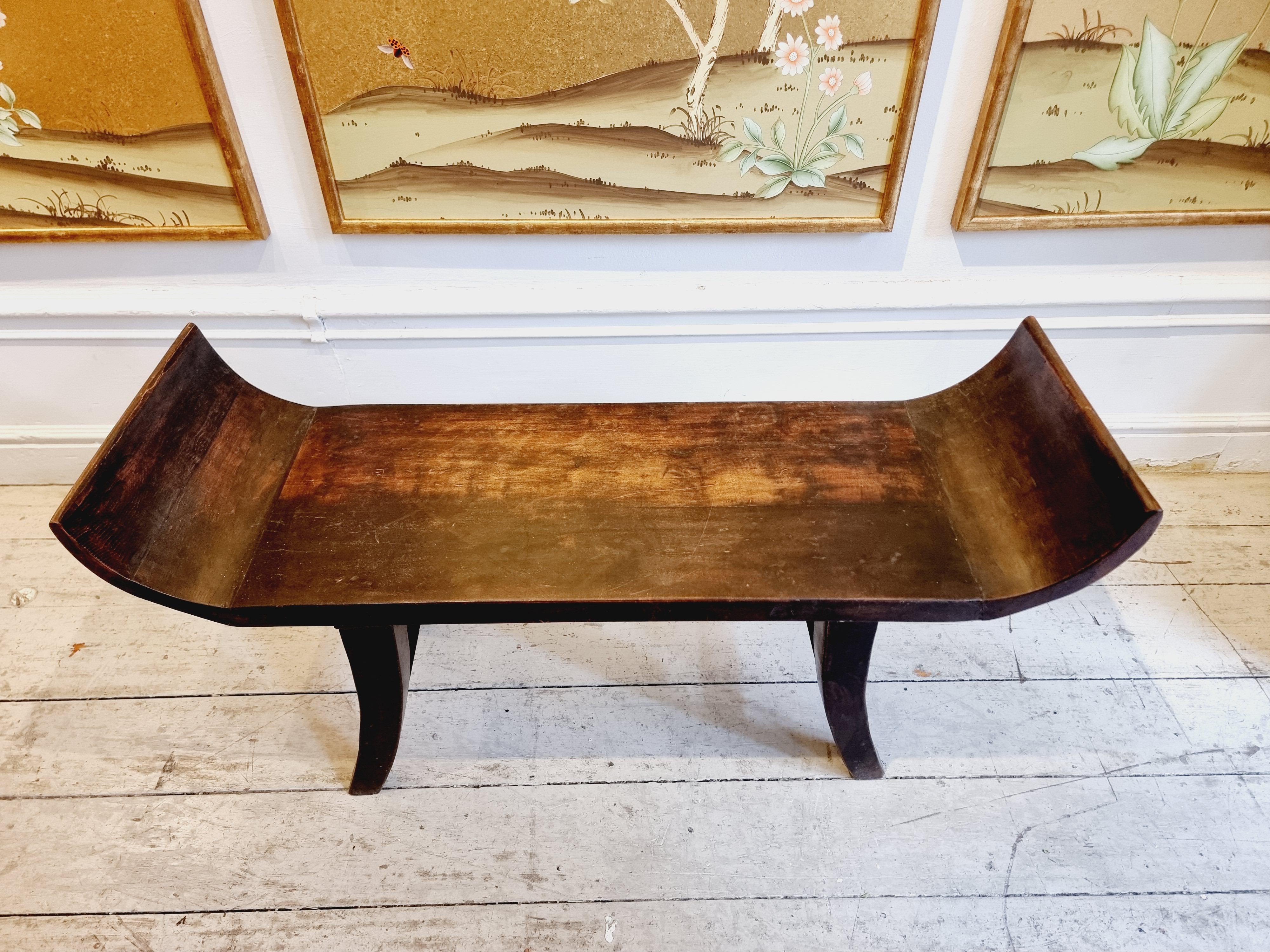 A decorative bench in dark lacquered wood. Made in Asia, late 20th Century. 

Beautiful sculptural shape and heavy, quality wood. Stabile and in good condition. Smaller signs of age and wear. 