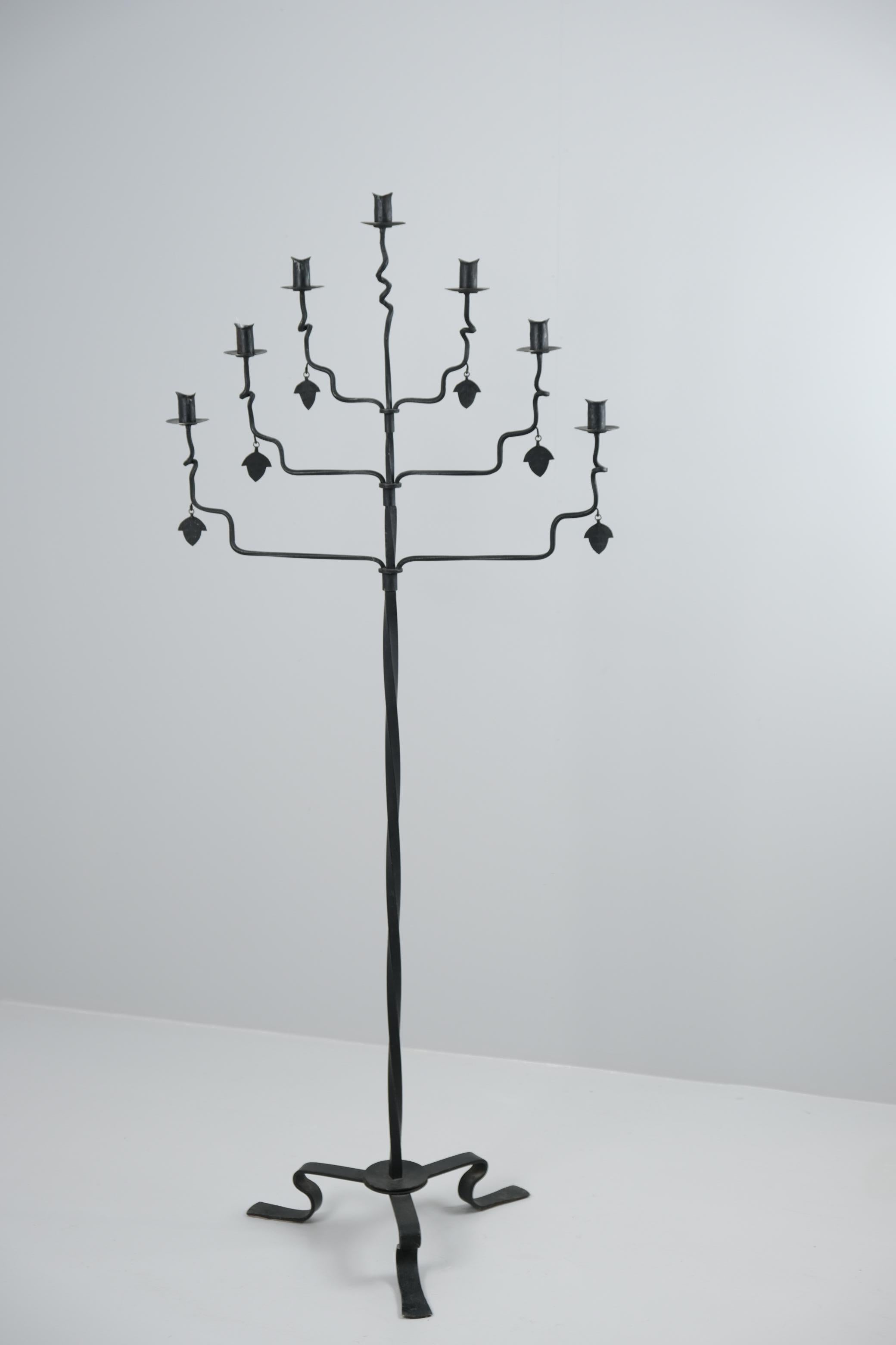 Una bellissima torchére / portacandele disegnata da Bertel Lindholm e realizzata dall'importante laboratorio finlandese di metallo e ferro battuto Taidetakomo A. Hakkarainen negli anni Trenta. Bertel Lindholm è stato un importante designer