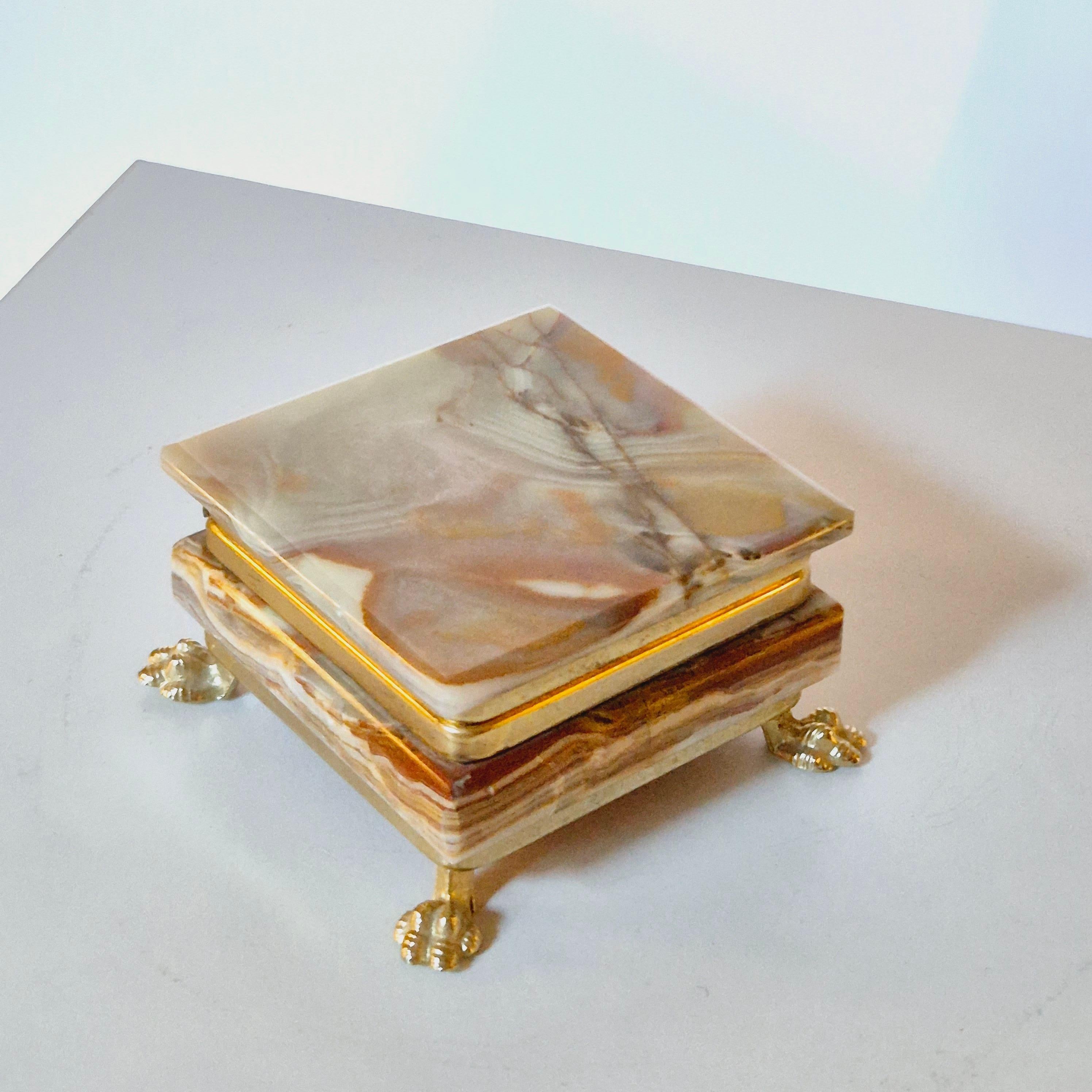 A decorative box in onyx with gilt metal lions feet. Perfect for smaller keepsake or jewellery. Italian, mid-1900s.

In good condition, smaller signs of age.