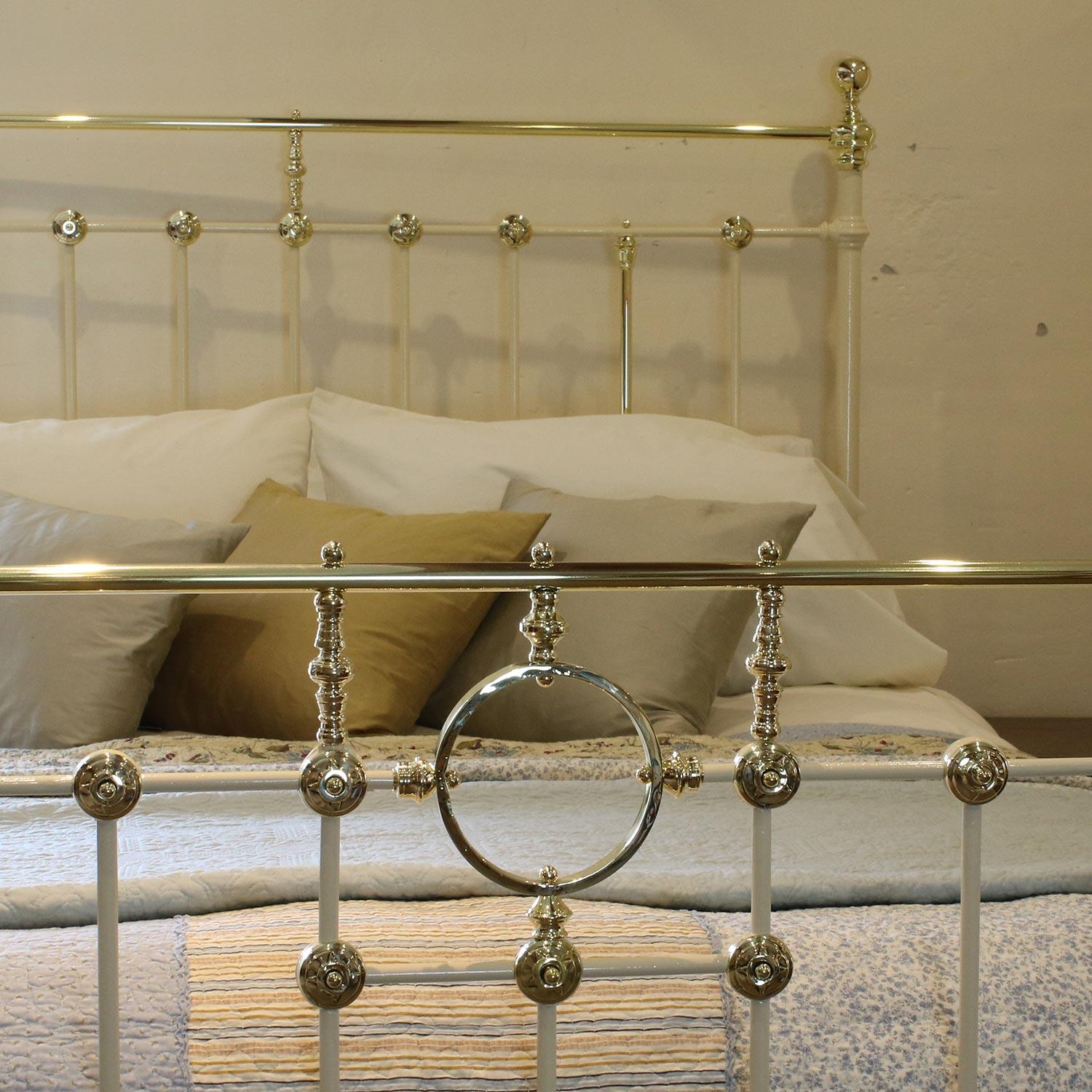 A brass and iron bedstead adapted from an original Victorian frame, finished in cream with decorative brass rosettes and central ring.

This bed accepts a British king-size or US queen-size (measure: 5ft, 60 in or 150cm wide) base and mattress