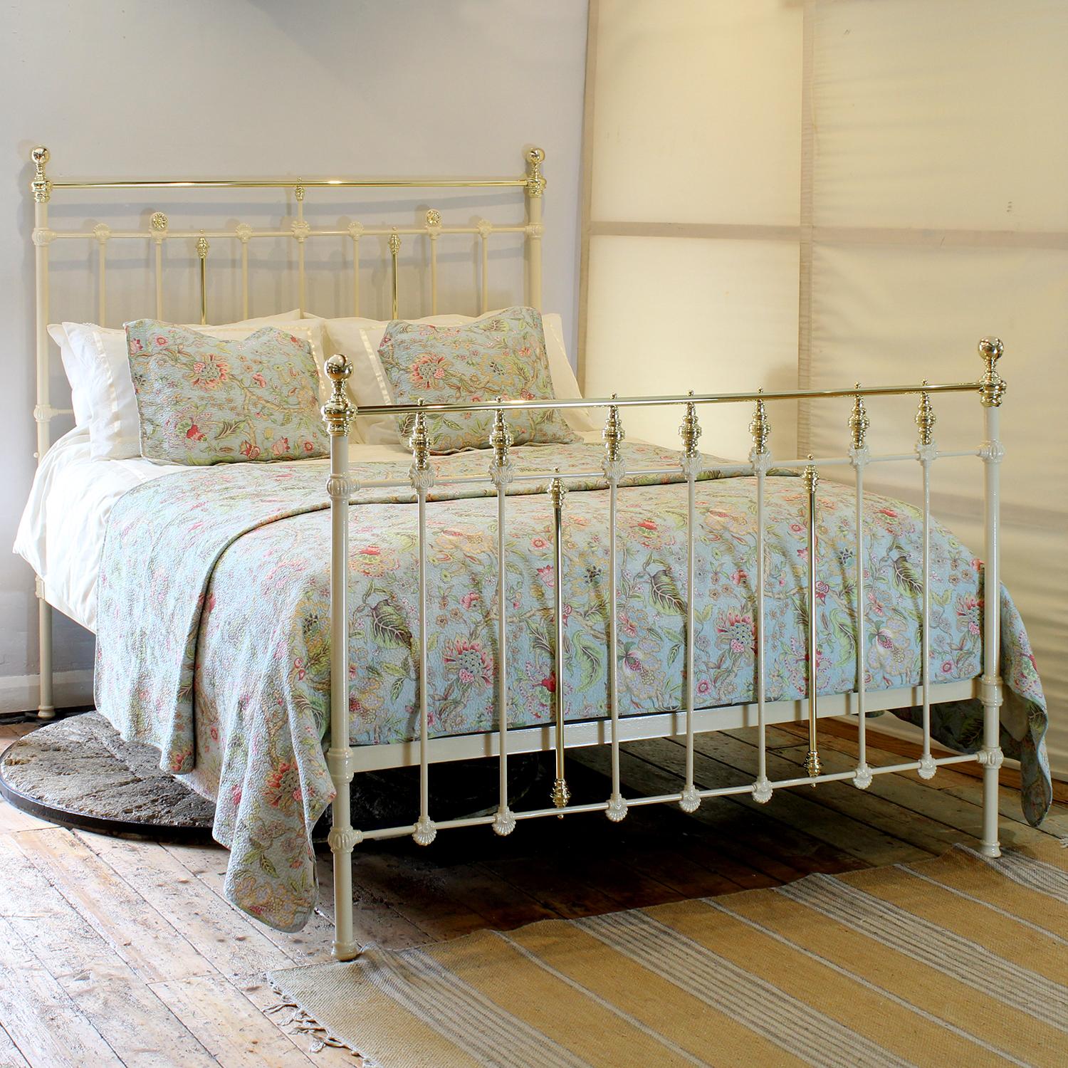 A Victorian brass and iron bed with decorative foot board featuring a row of brass trumpets and head board featuring raised rosettes, finished in soft cream.

This bed accepts a US Queen size (or UK King Size) 60 inch wide base and mattress