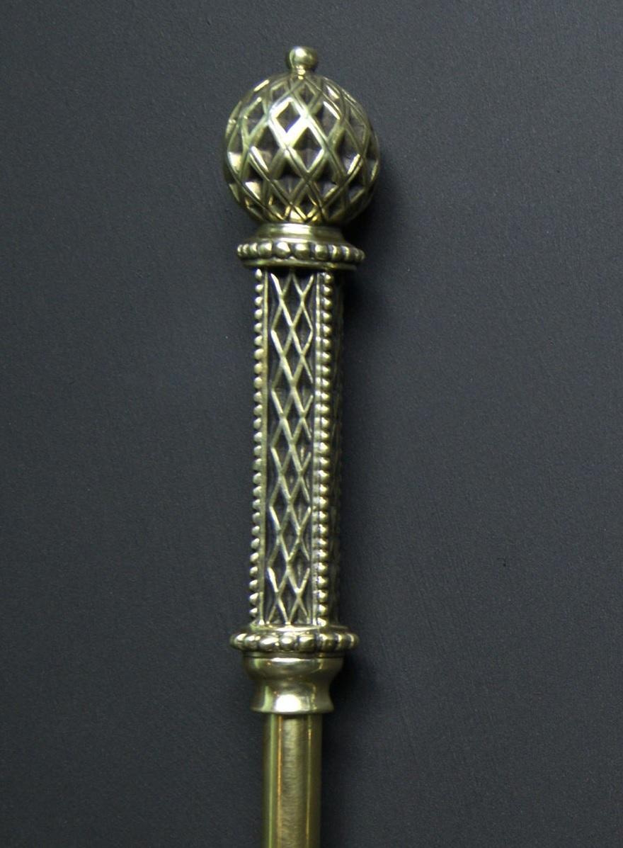 A set of decorative brass Art Deco fireplace fire tools with fine lattice-work and beading to handles and sphere finials uppermost.  The set comprises of a poker, tongs and shovel. The sweeping scalloped pan is attached with copper rivets and