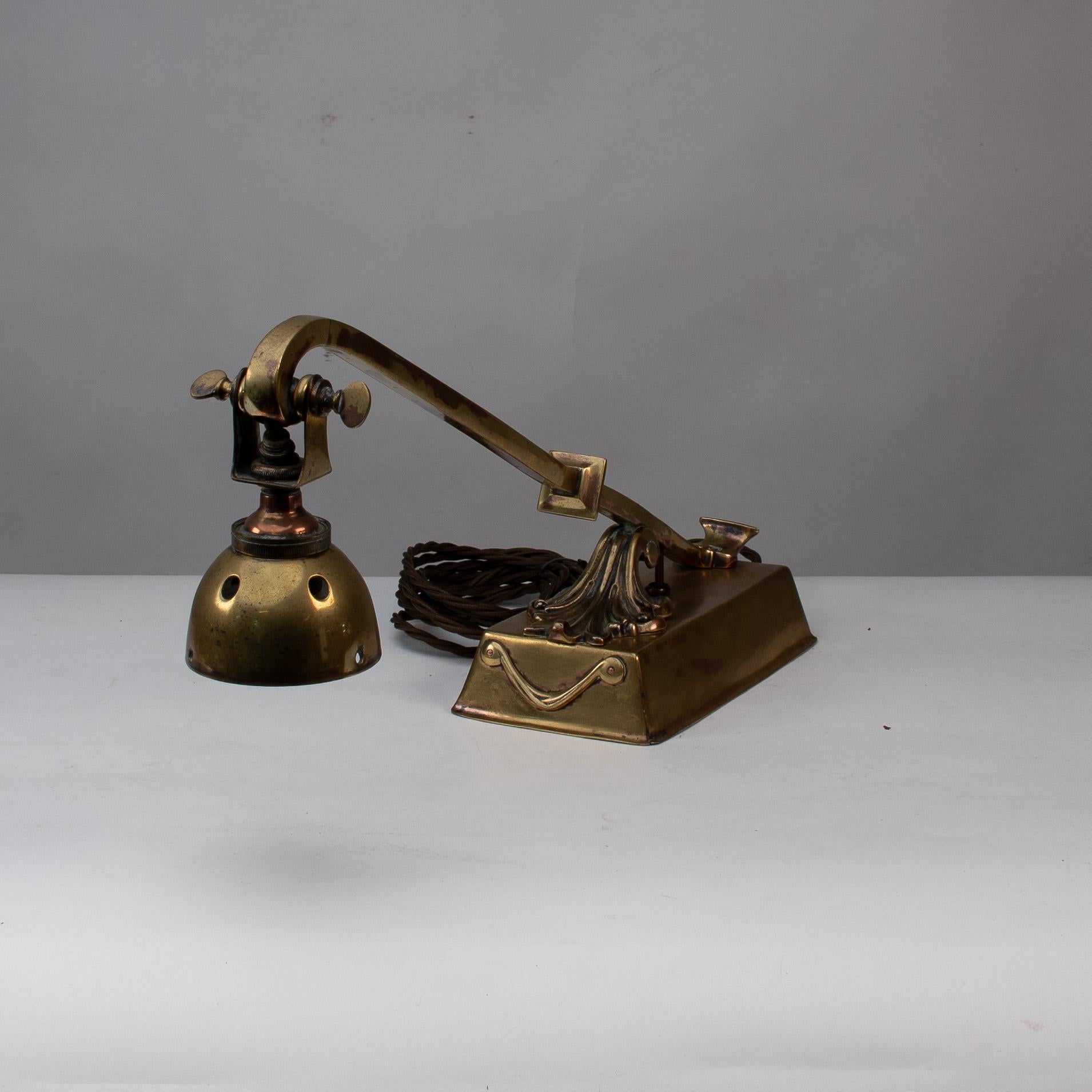 A decorative brass desk light with chord and adjustable head.

