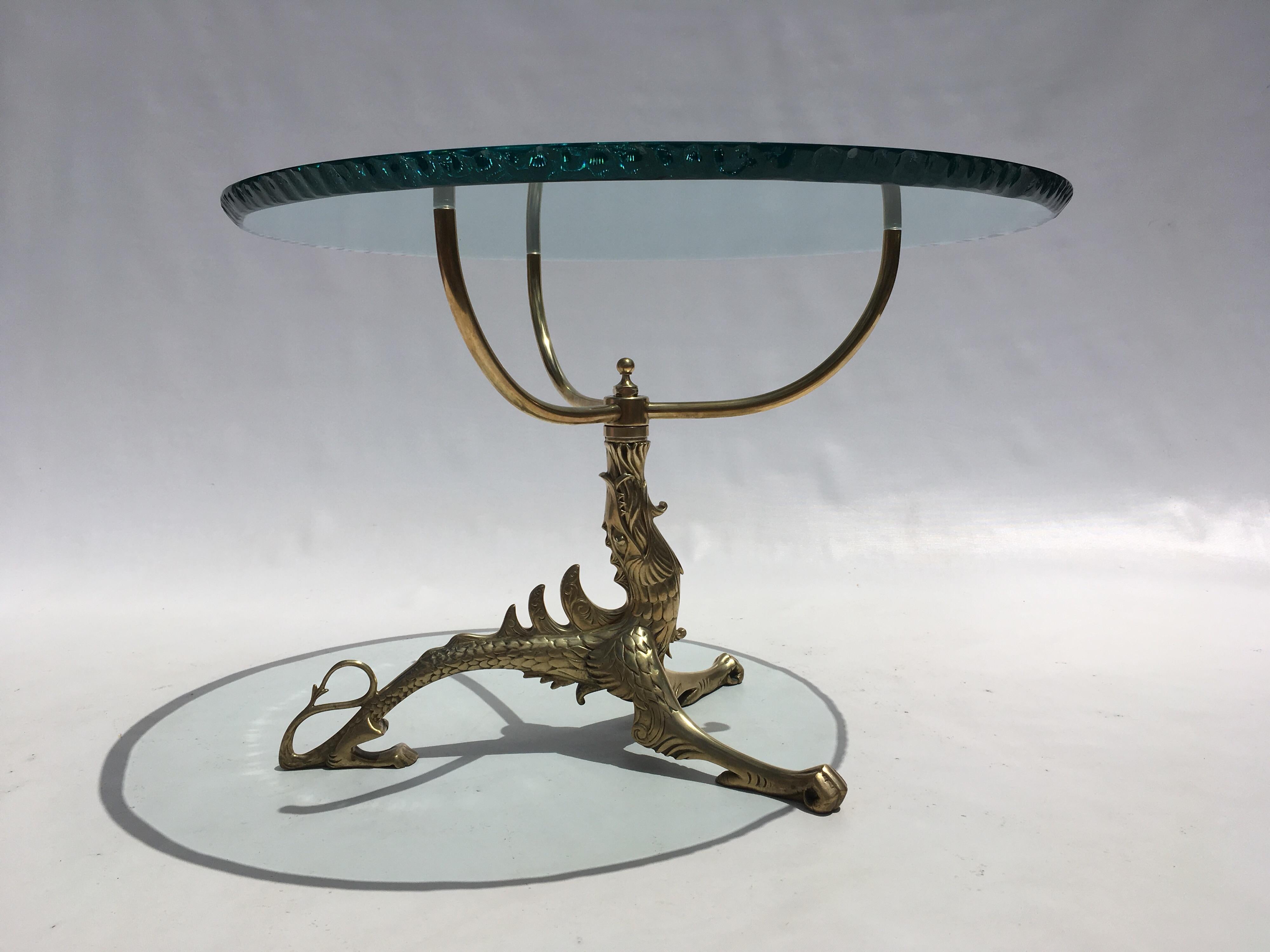 Dragon spitting fire brass table, the glass top has a chipped edge design.
