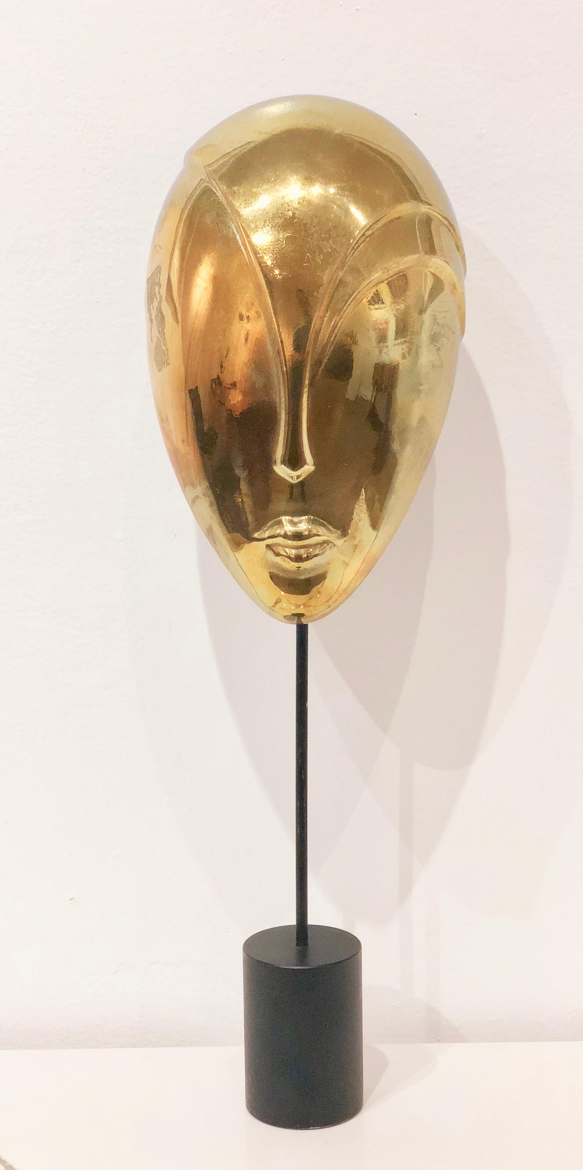 Unique solid brass decorative mask sculpture in polished brass finish with black enamel finish bases.