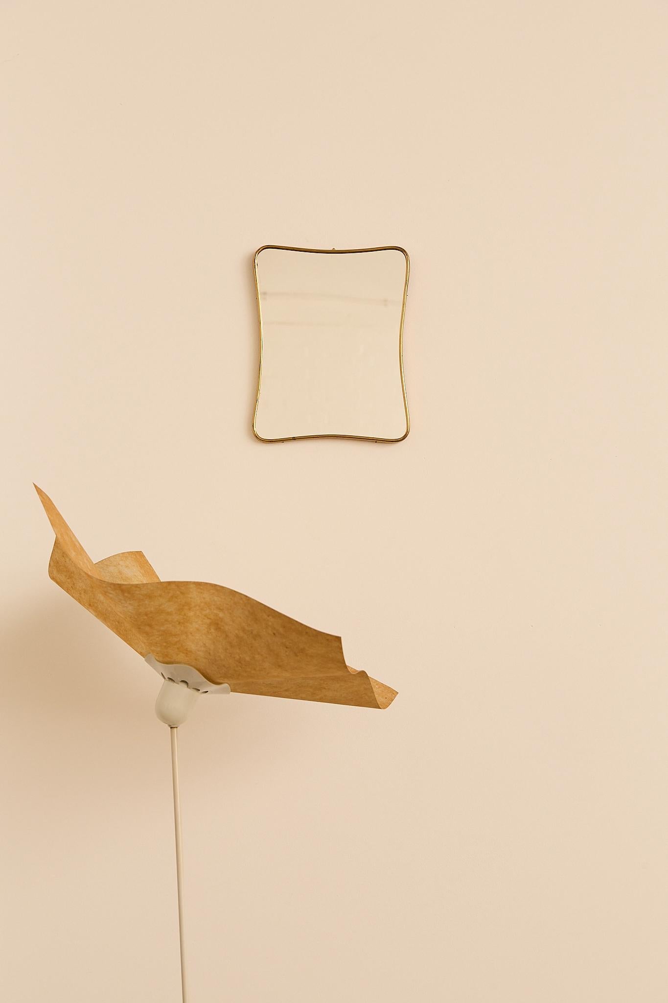 Featuring a gently curved rectangular form with a slim brass frame, this piece combines simplicity and elegance