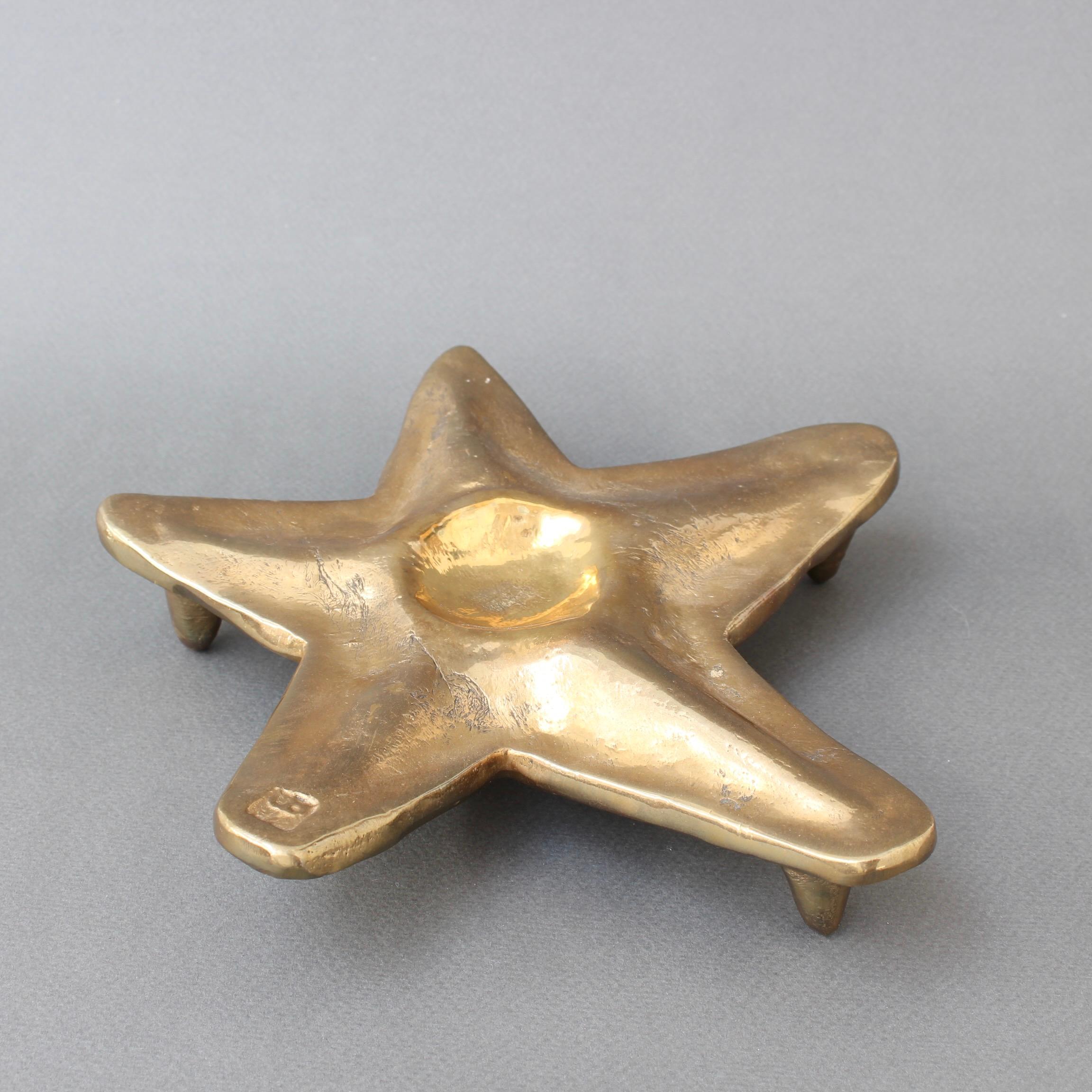 Brass trivet by David Marshall (circa 1990s). This piece is weighty, elegantly rugged, beautifully trodden and in the form of a starfish. It looks like it has had a rough life and therein lies its beauty. Raw, brutal and alluring. Maker's mark