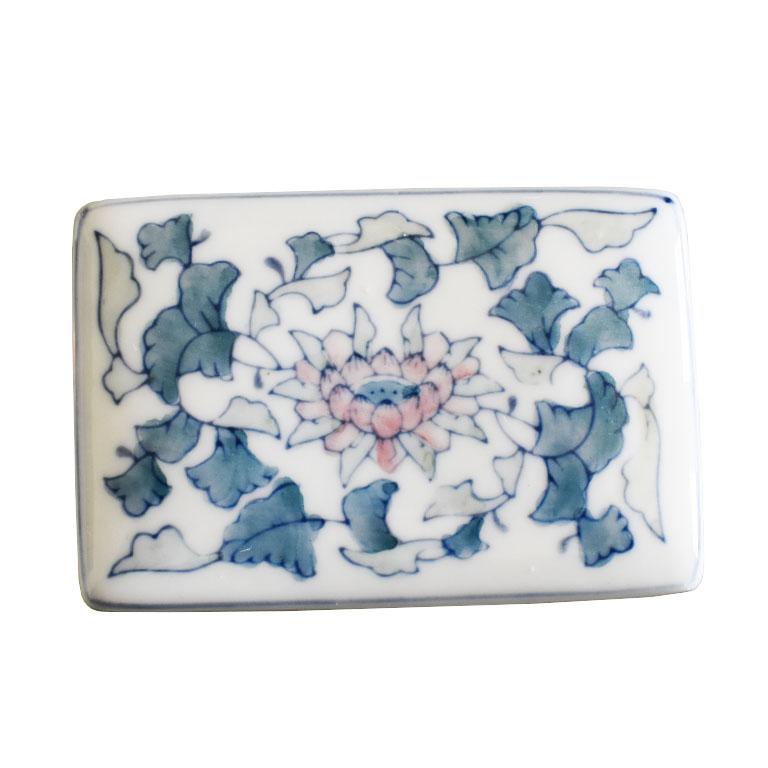 A small Chinoiserie ceramic decorative box with a lid. Rectangular in shape, this box features a hand-painted floral motif on the top of the lid as well as on each of the four sides. 

Dimensions:
4.5