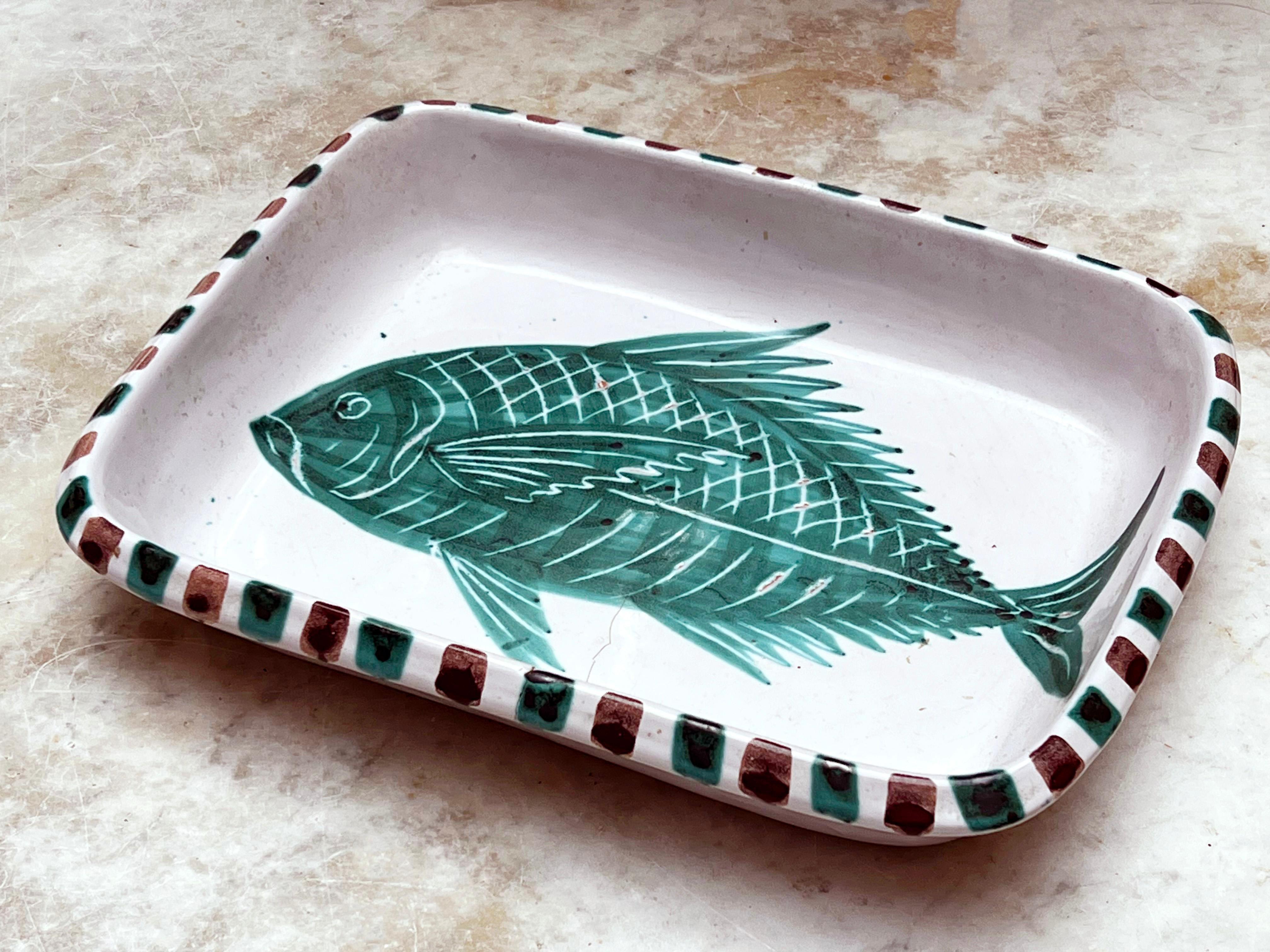 Plat décoratif rectangulaire en céramique provenant de Vallauris dans le sud de la France, signé par Antoine Fazio dans les années 1960. Décor de poisson avec des points ocre rouge et verts sur tout le pourtour. Antoine Fazio a travaillé à Vallauris
