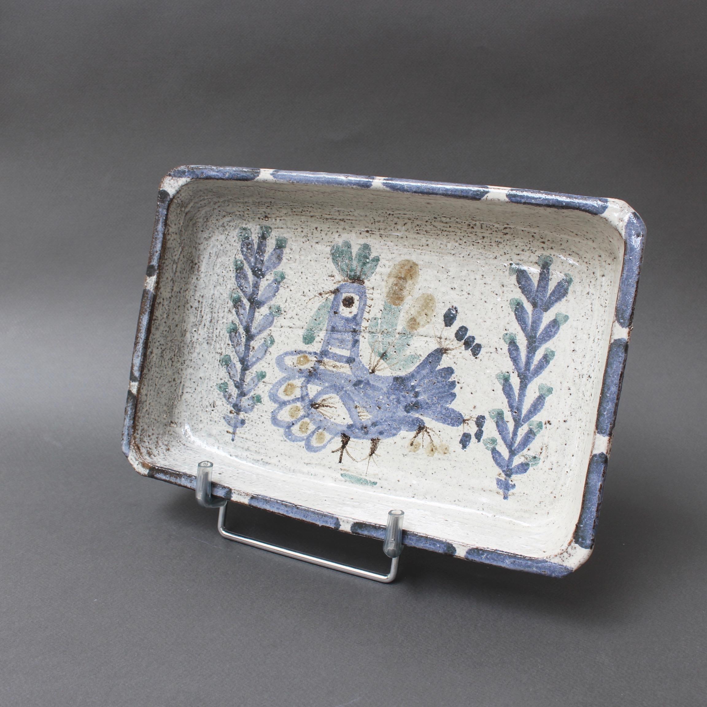Decorative ceramic rectangular dish by Gustave Reynaud, Le Mûrier, (circa 1950s). This utilitarian crockery dish is also a delightful work of art. On the rustic base is a stylized, French rooster flanked by plant motifs framed in Reynaud's