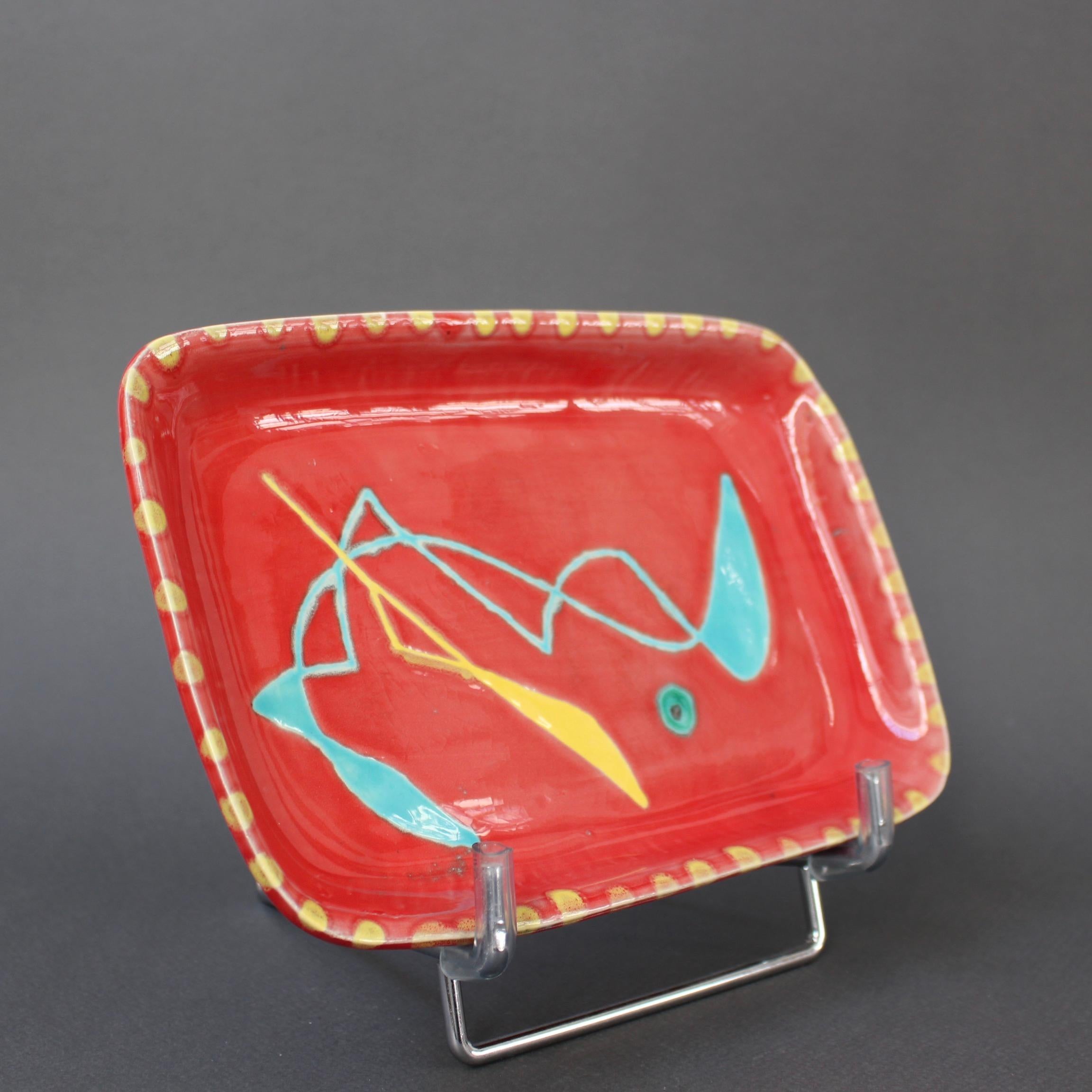 Keramikschale für Vorspeisen aus der Mitte des Jahrhunderts von Charles René Neveux für Cerenne Workshop (um 1950). Diese seltene Keramik mit abstraktem Motiv ist von Neveux selbst signiert. Ein tomatenroter Sockel wird durch ein gelbes, sich