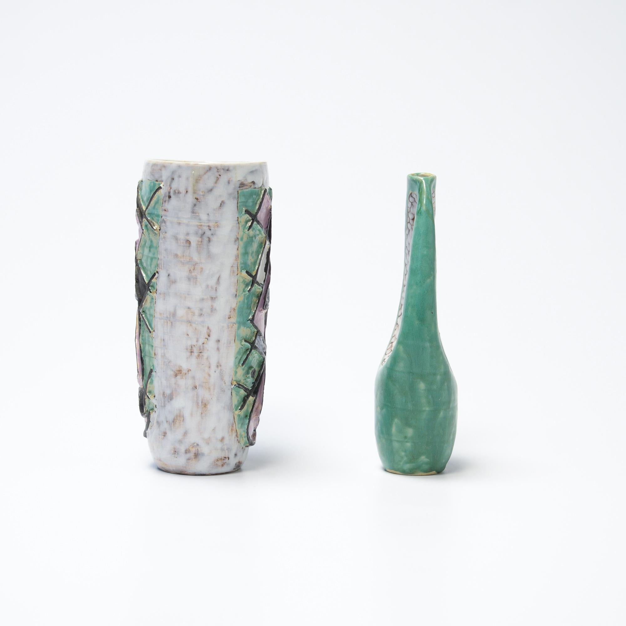 Dieses dekorative Paar Keramikvasen ist auf 1957 datiert.
Es ist ein schönes Set in mintgrün, helllila, schwarz und weiß.
Die Vasen sind in sehr gutem Zustand. Beide Vasen sind markiert.
 