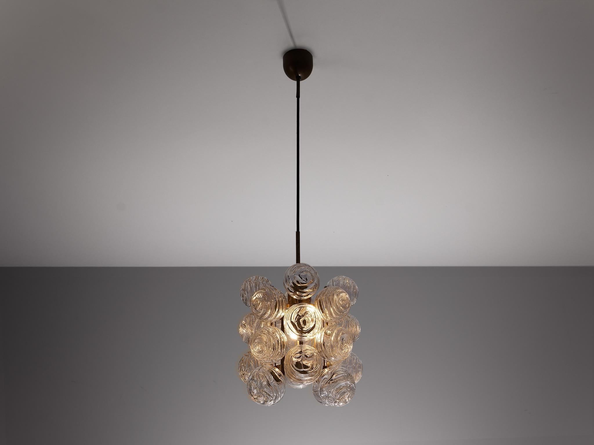 Doria Leuchten, chandelier, brass, glass, Germany, 1960s 

This elegant chandelier is decorated with textured glass spheres which are attached to a patinated brass fixture. The light from within the shade shines through the snowballs, creating a