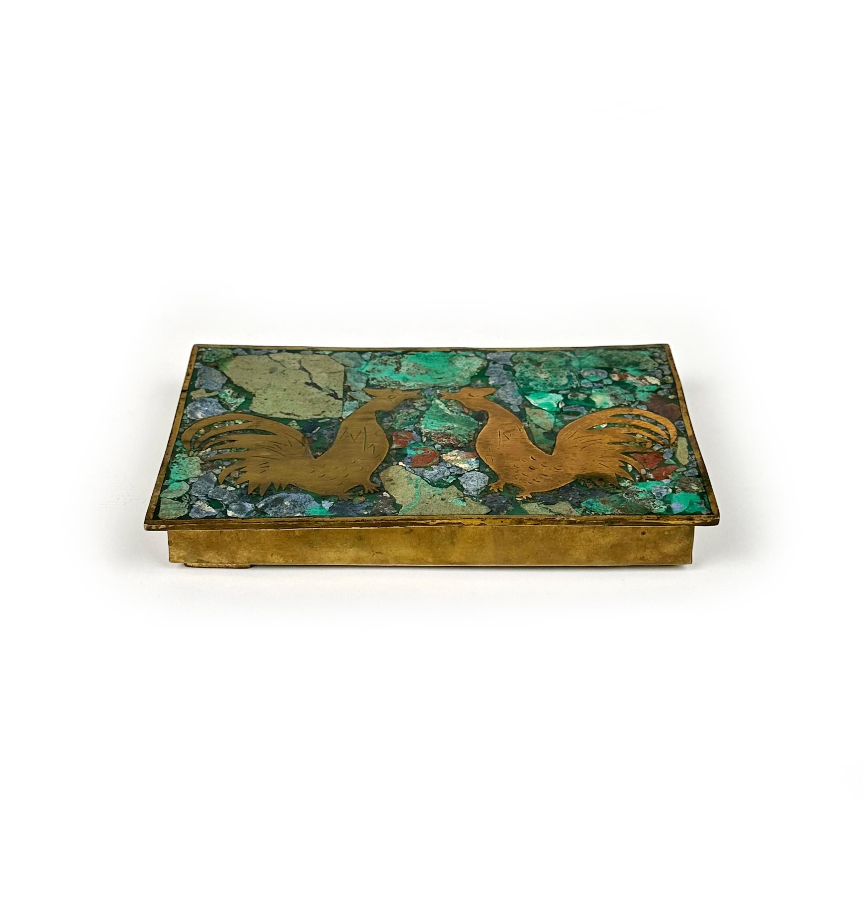 Beautiful hinged inlaid malachite and sodalite (or lapis lazuli) brass metal box with wood interior. 

Two roosters grace the lid. The metalsmiths of Taxco, Mexico were known for producing this type of cigar box in the 1960s.

Made in Mexico in