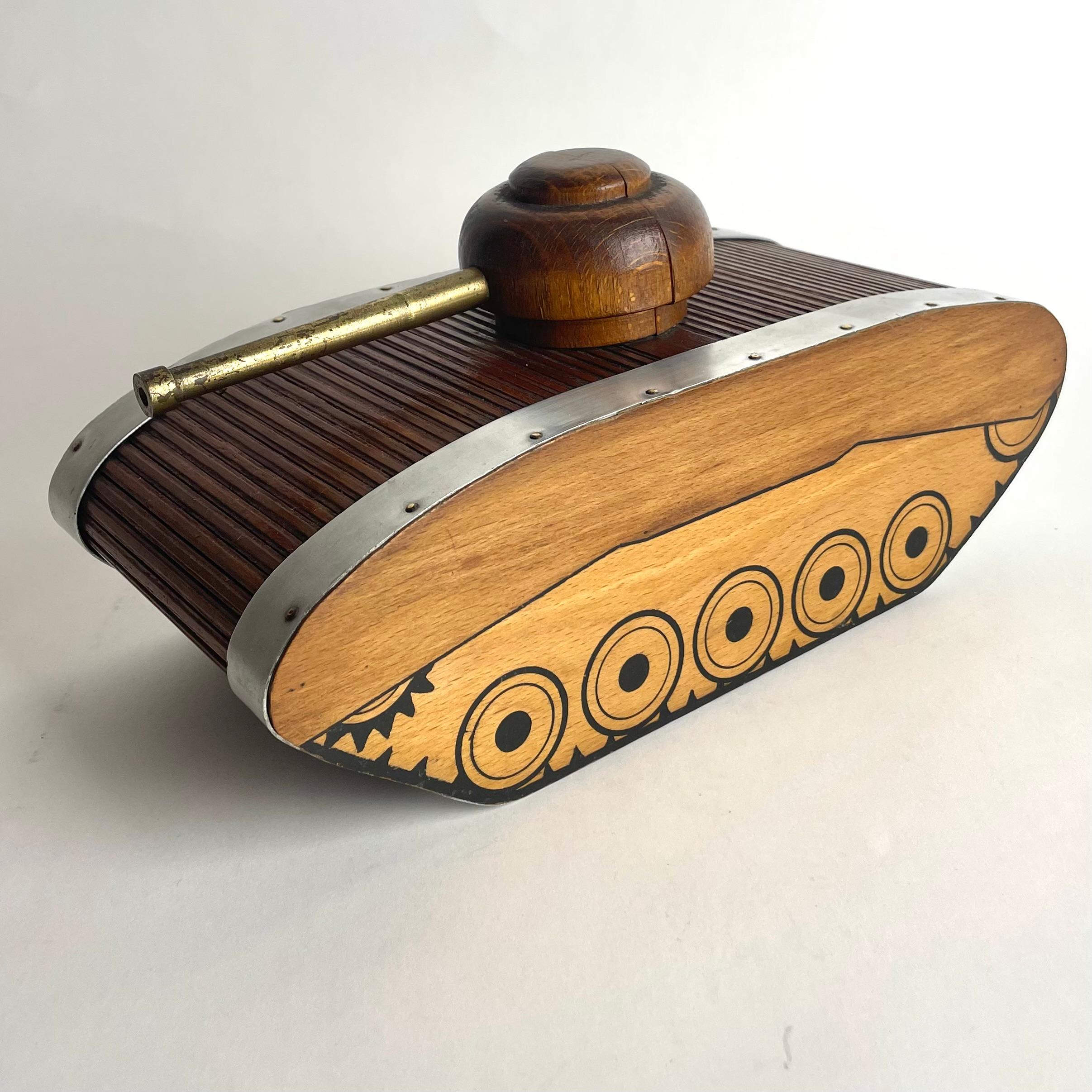 Decorative Cigar or Cigarette Box in the shape of a tank from the 1940s. Made in beech wood with details in aluminum and with a cannon barrel in bronze. 


Wear consistent with age and use 