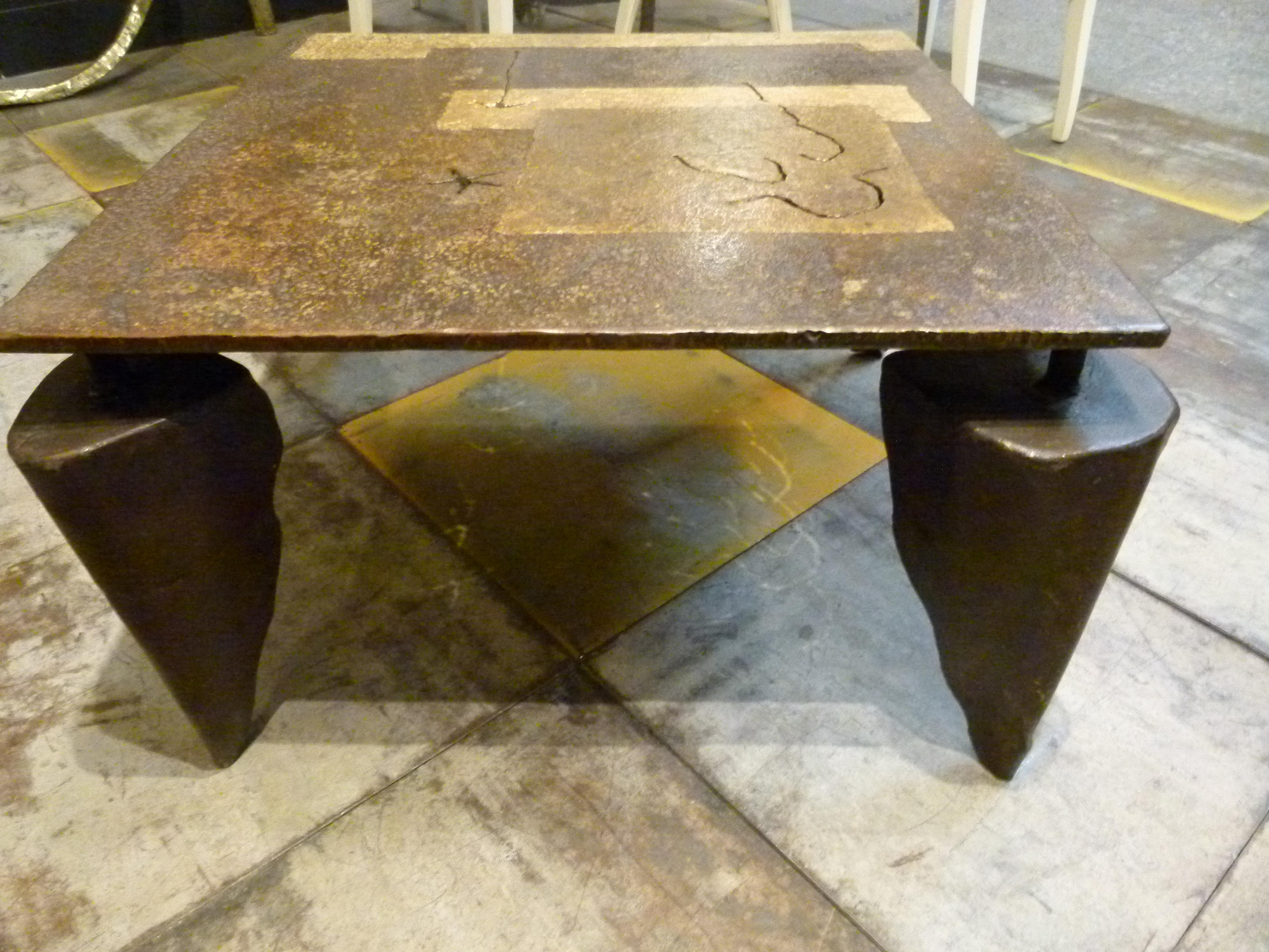 This decorative table from Jean-Jaques Argueyrolles, is itself piece of art. The way in he mixes materials, is unique, and makes this piece of furniture an irrepetible work of art. 
The top is a mix of recycled ship Iron with gold leaf and the four