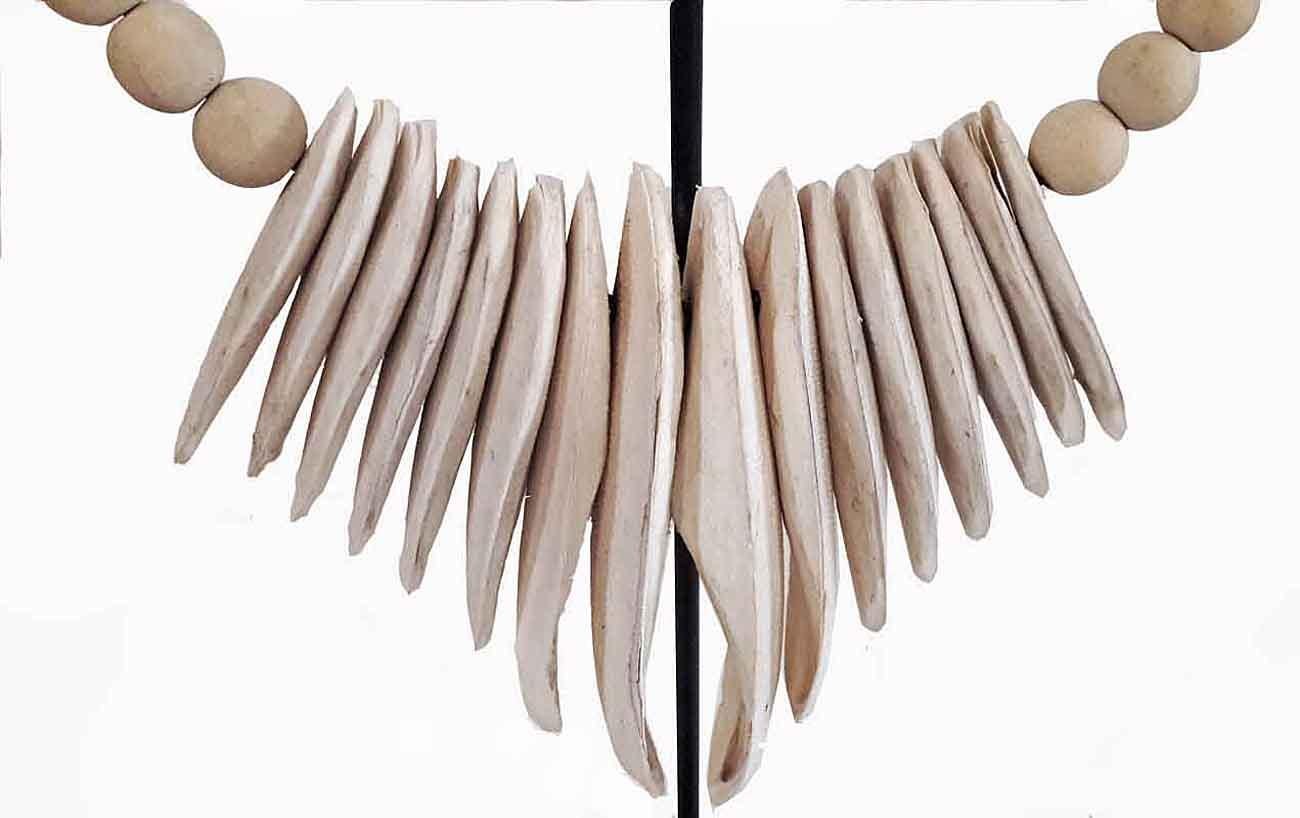 A decorative necklace from Indonesia, made of cuttlefish bones. A singular piece of Balinese handcraft that will add an exotic touch to any eclectic decor. Mounted on a black metal Stand for maximum display effect.
 