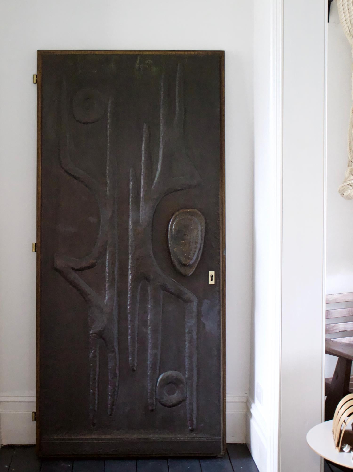 An impressive solid oak door, clad to one side in hammered copper with a wonderful abstract design. Found in Germany, probably dating from the 1970s. A solid, heavy piece, nicely made, in good condition, with minor signs of wear from age and
