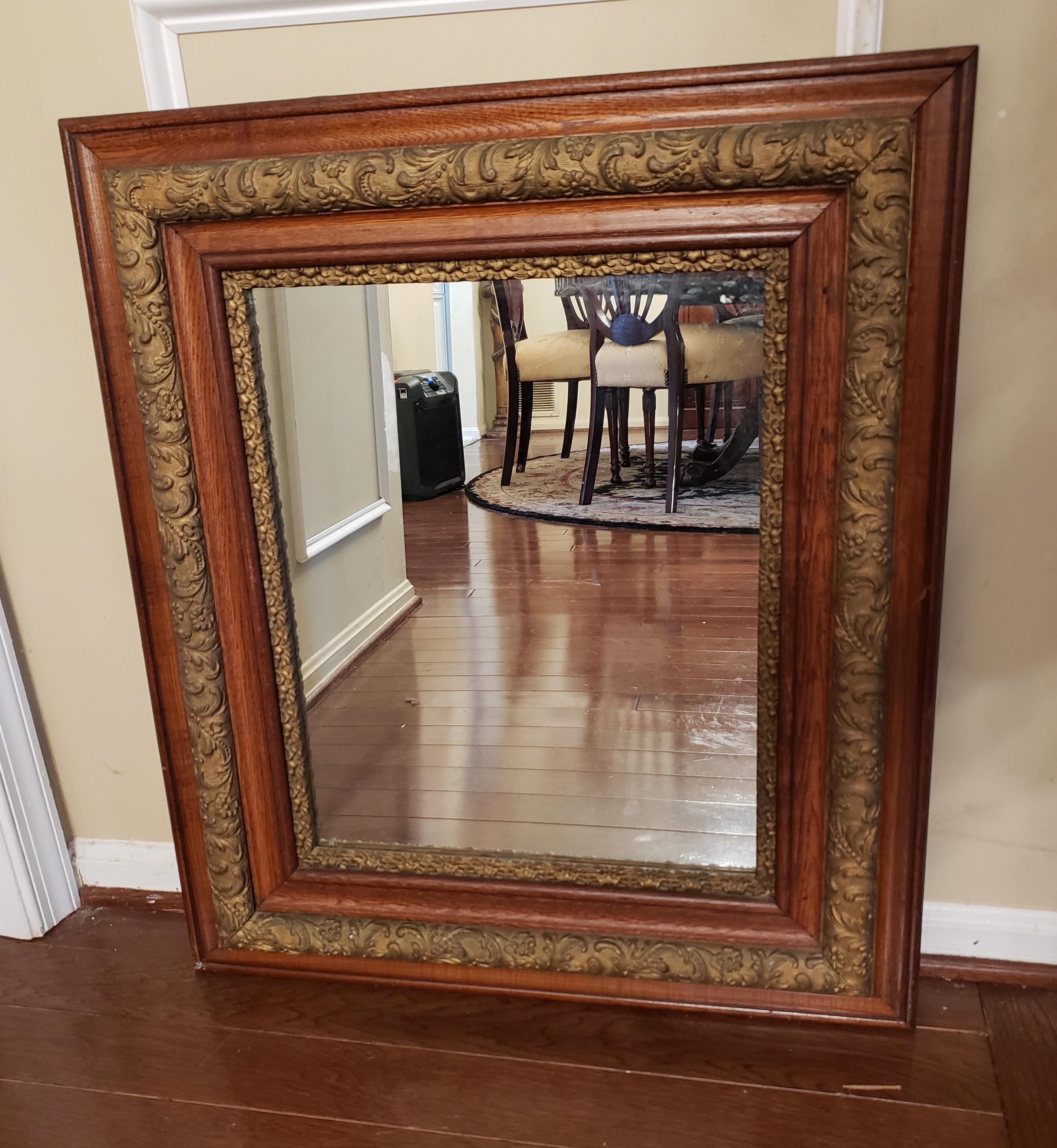 Beautiful Decorative Antique Victorian oak and gilt mirror. Features a double solid oak Frame. Frames are separated by exquisite, thick gilt work with raised floral decor throughout. Very good condition. Circa1890s

Measures 26.25