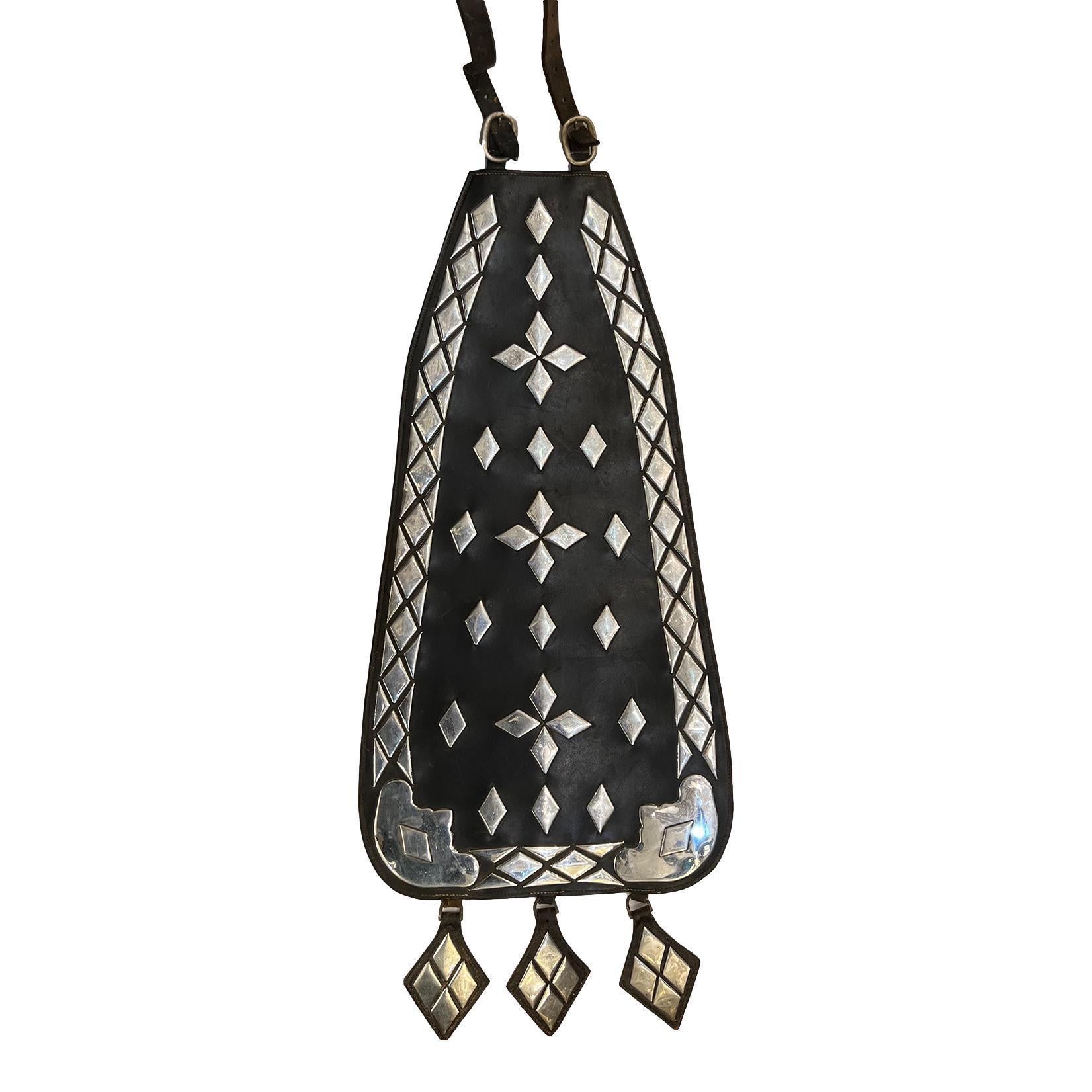 Une décoration de selle espagnole des années 1950 en cuir et détails nickelés.

Mesures :
Longueur : 60.5″
largeur : 15.75″
