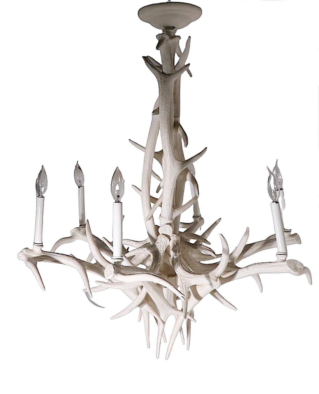 Faszinierende Geweihimitation aus Aluminiumguss in antikem Weiß auf weißem Grund. Der Kronleuchter verfügt über sechs Kerzenglühbirnen, die mit Standard-Schraubglühbirnen bestückt werden können. Er ist in gutem Zustand und bereit zur Installation.