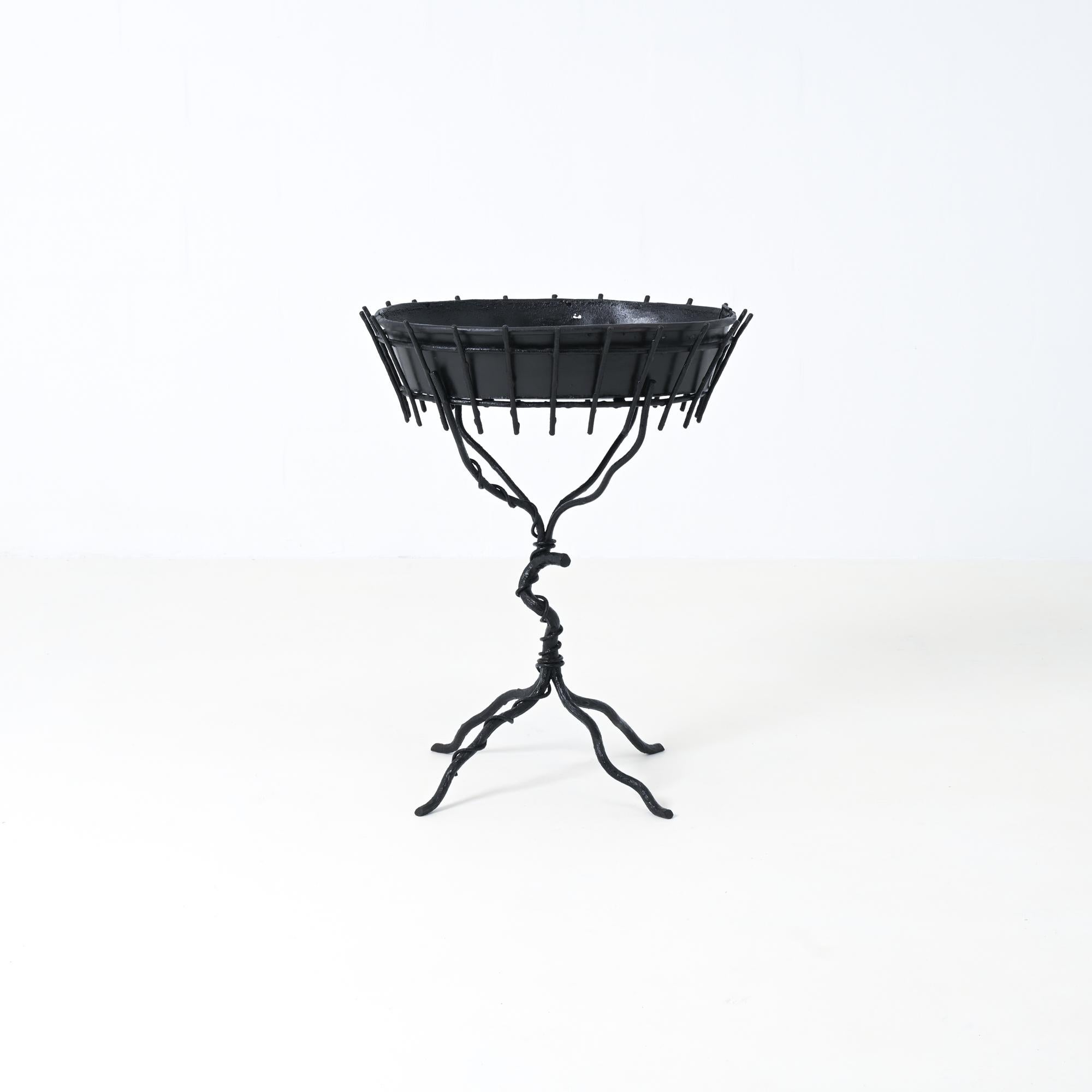 Questa fioriera in finto bois è stata creata dal decoratore francese Jean-Michel Frank. È sofisticato e realizzato in metallo forgiato laccato nero.
La fioriera è in buone condizioni, la ciotola in metallo presenta alcuni danni, come visibile nelle