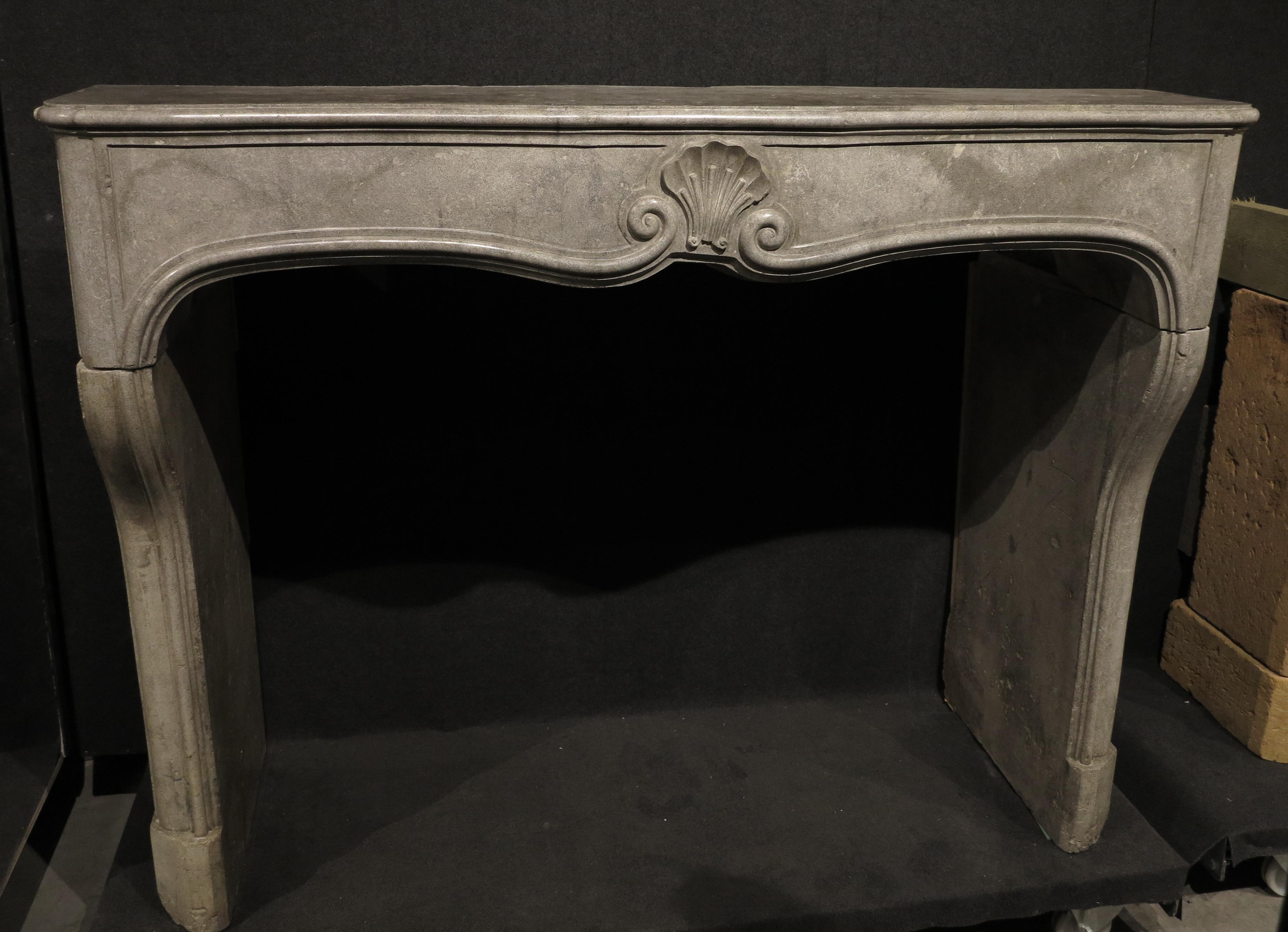 Captivating grey-colored decorative fireplace mantel with beautiful ornamental carving in the shape of a shell. If you are looking for the perfect piece to complement your classy, sophisticated interior, this breathtaking fireplace will fit right
