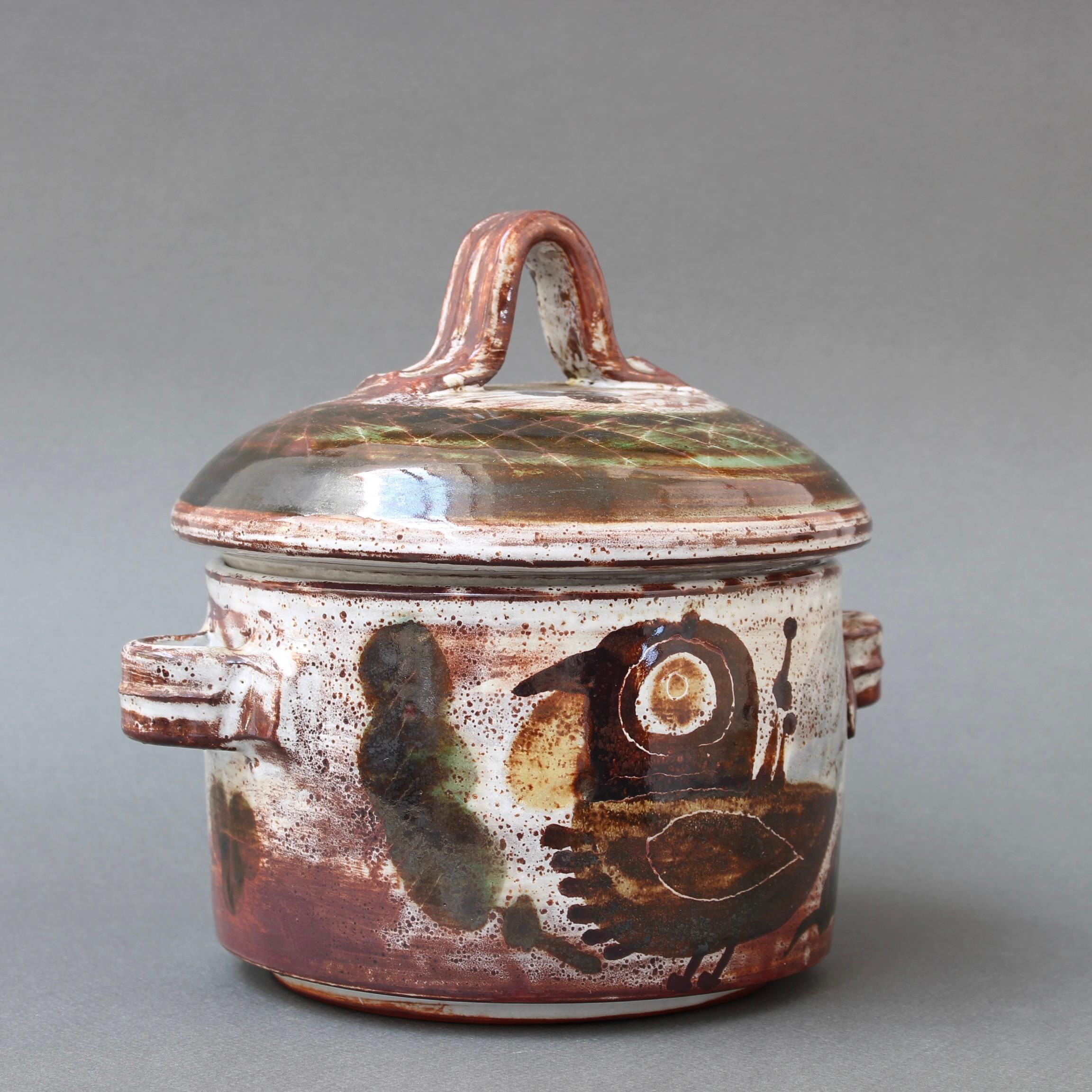 Pot décoratif vintage en céramique avec couvercle de Michel Barbier (circa 1960). Ce pot utilitaire avec couvercle est également une œuvre d'art étonnante. L'extérieur brillant est orné d'un oiseau stylisé et de motifs végétaux encadrés dans les