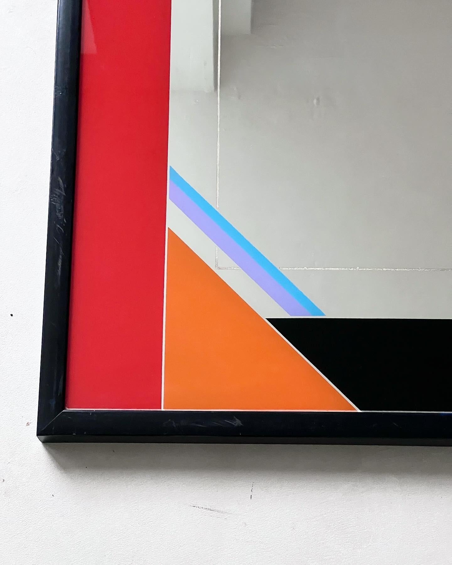 Decorative wall mounted mirror designed by artist Eugenio Carmi for italian furniture brand Acerbis and manufactured in the 1980s. Its an exquisite Space Age Era artifact, and its vibrant colors and geometric pattern closely echo the inspirations of