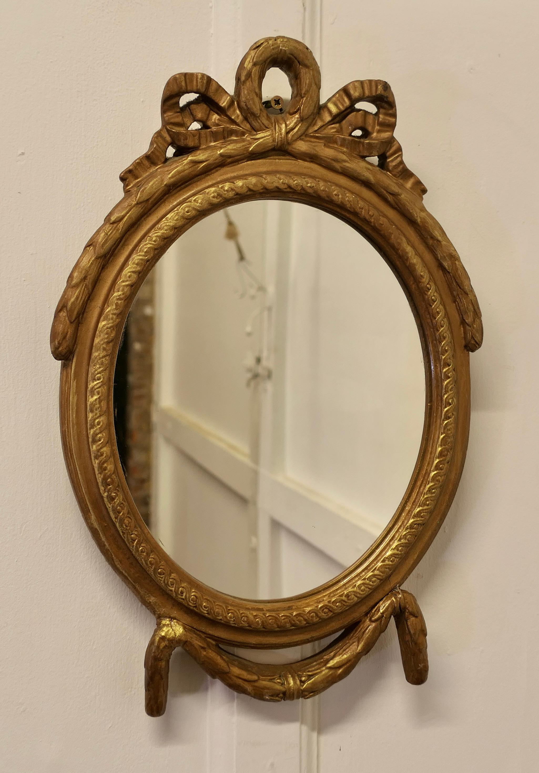 Decorative Gilt Oval Mirror

This Mirror has a 1.5” wide moulded oval frame, it has a decorative ribbon swag at the top and this a good dark gilt finish
The Oval frame is in attractive condition 
The mirror is 12” wide and 19” tall 
FB52