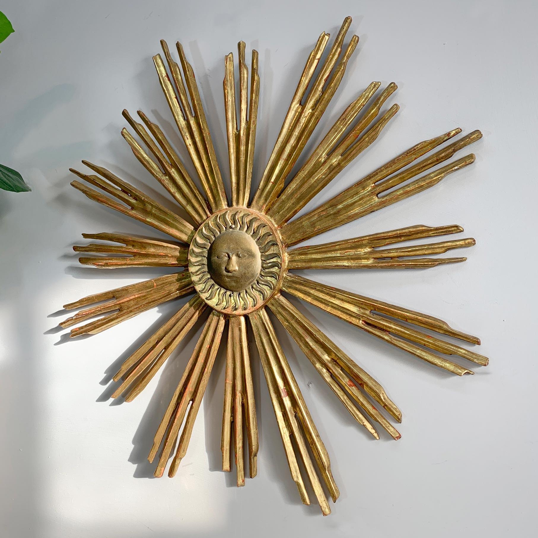 A circa 1920 highly decorative water gilded Italian sunburst, hand carved wooden rays with a brass sun face to the centre.

Original hanging hook to the rear.

Width 55cm x Depth 5cm.