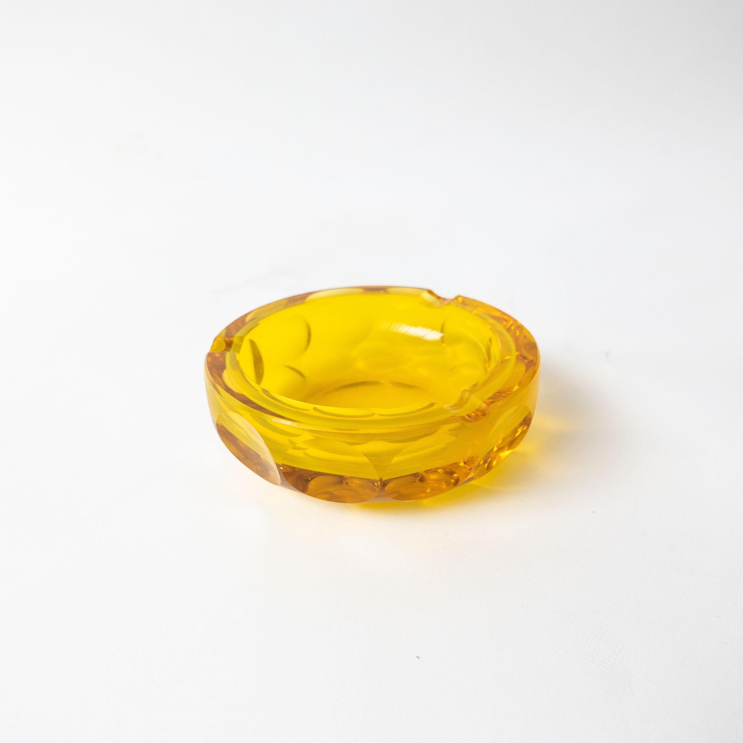 Decorative bowl in yellow glass with a dotted pattern all around. Originally intended as an ashtray, as proven by the three notches around the edge, but likelly never used as such, given the absence of any kind of mark from the bottom. 

As shown in