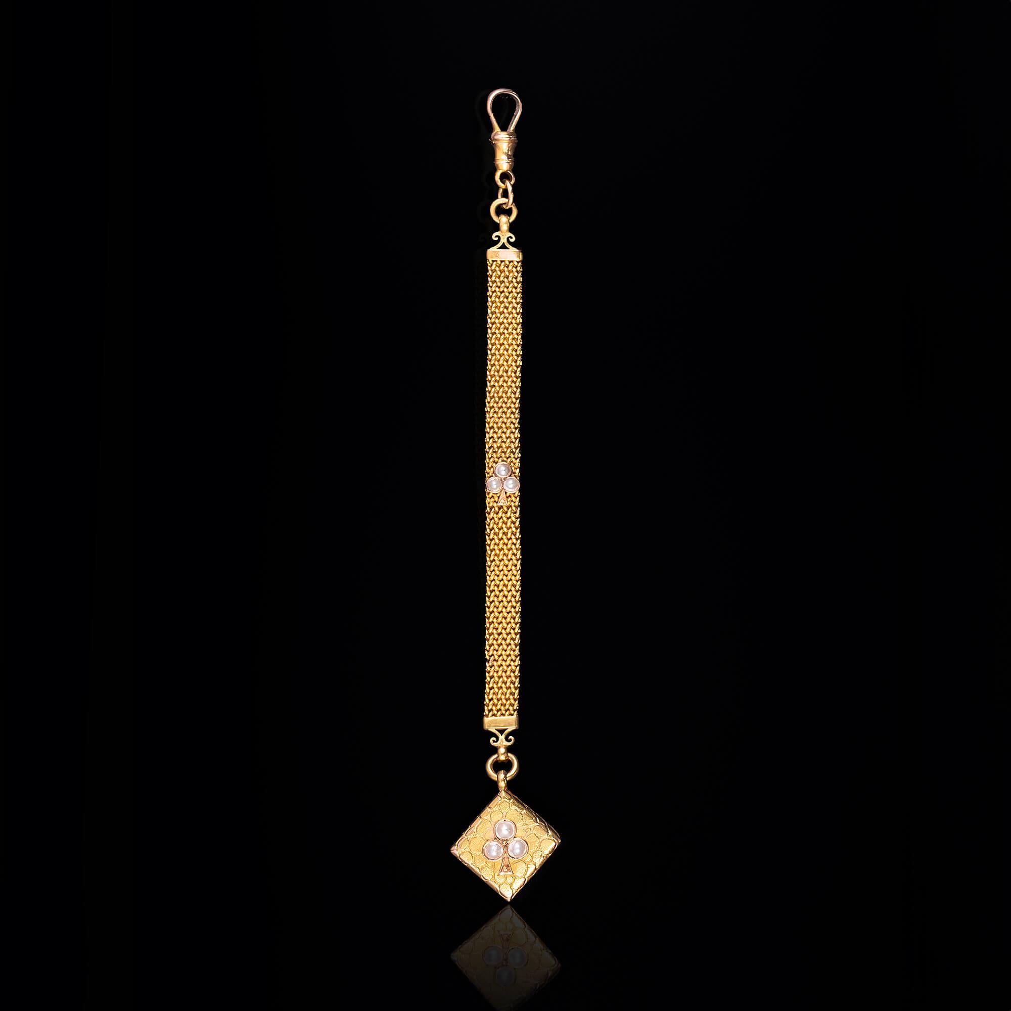 A decorative Edwardian fob featuring a capped yellow gold mesh chain with a central 30pearl set club symbol depicting a very stylised three-leaf clover with its stalk oriented downwards on each side. A hand engraved textured square charm is