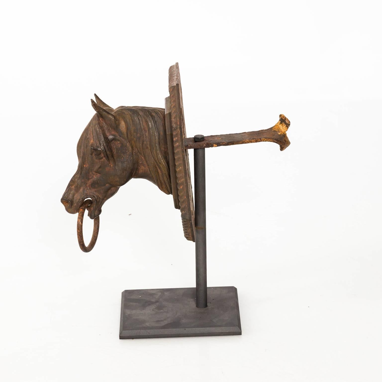 20th century decorative iron horse head in a weathered, rusticated finish on a black metal base, circa
 