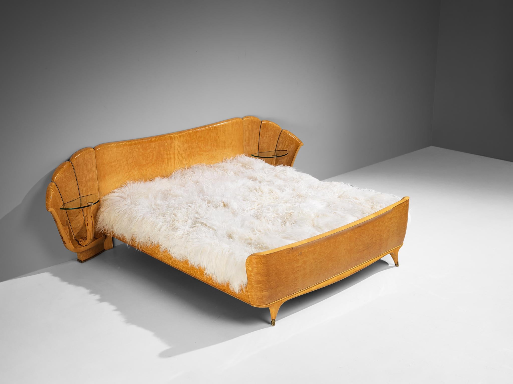 Queen bed, ash, glass, brass, Italy, 1950s

Queen bed with two integrated side tables. The shape of the headboard features a dynamic design with slightly curved sides and shell-like design. Vertical lines with little brass nails structure the