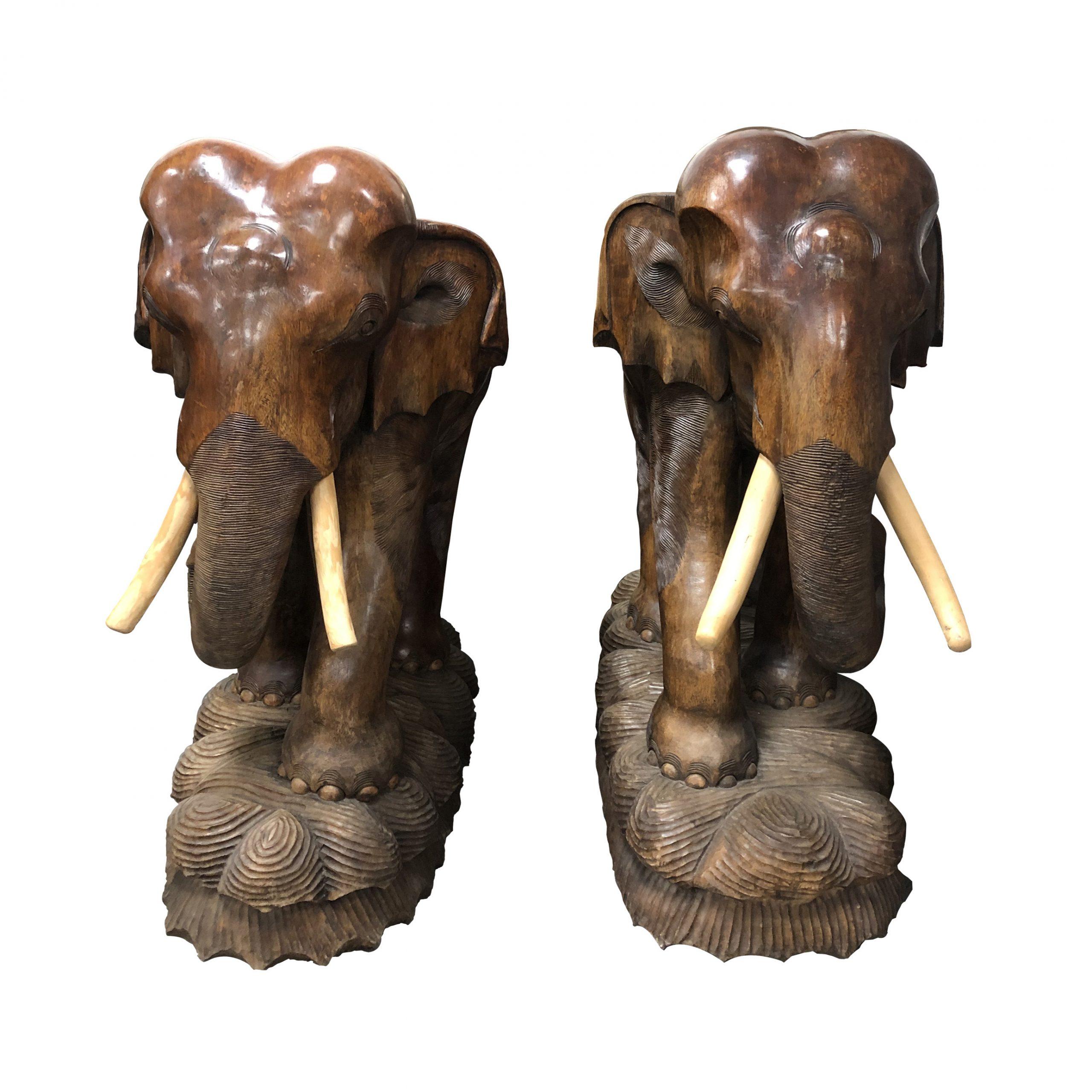 Il s'agit d'une paire de sculptures d'éléphants en bois sculptées à la main, très décoratives, avec des détails magnifiques et des courbes et des postures très réalistes. Les éléphants sont sculptés dans du bois dur, y compris les