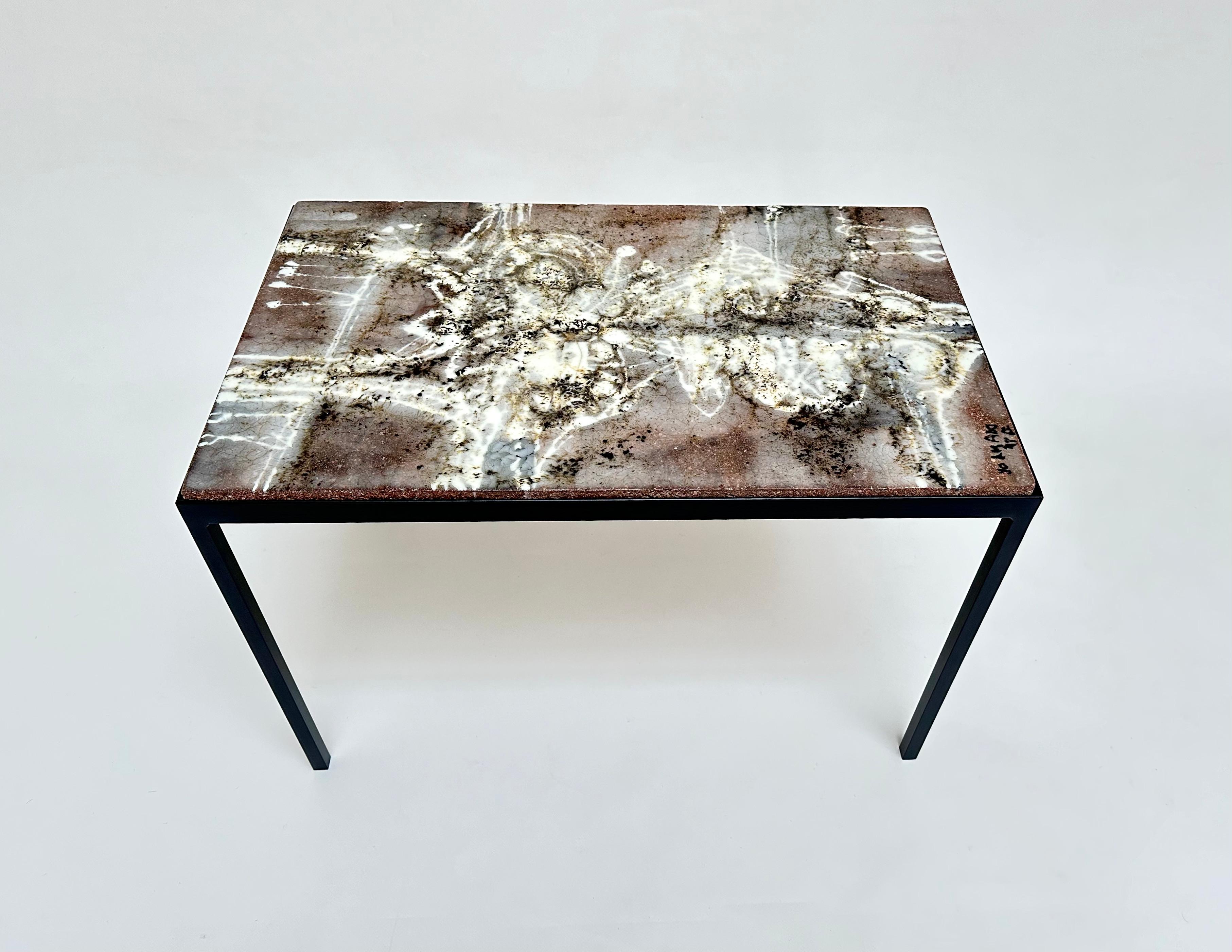 Elegant side table made of a thick slab of glazed concrete with an abstract pattern resting on a lacquered steel base, signed and dated.

 About the Artist 

Jo Amado (b. 1917 - d. 1963) is one of the more prominent ceramists of the Aix en Provence