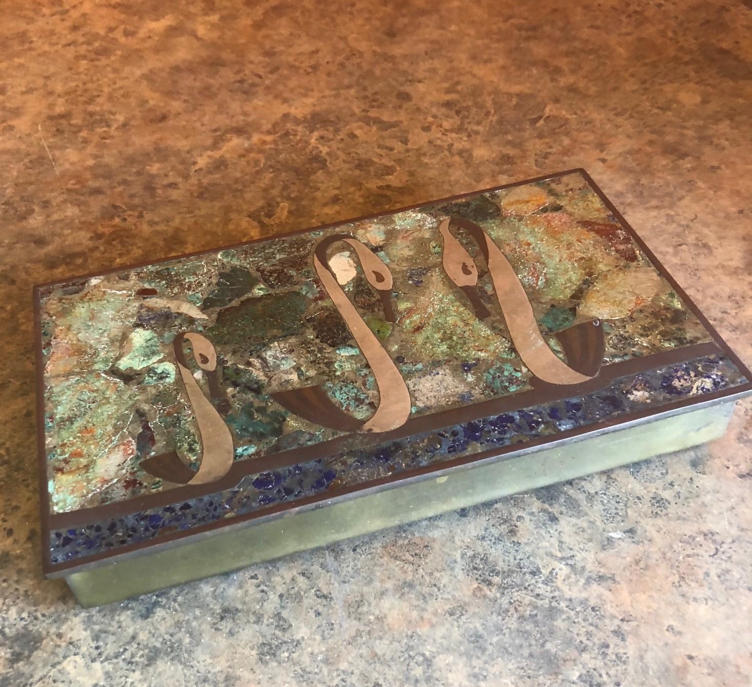 Beautiful inlaid detail of three swans in brass and bronze on a malachite and sodalite background adorn the top of this hinged box which was made by Los Castillo of Mexico, circa 1960s. The brass box is lined in rosewood and was probably used a