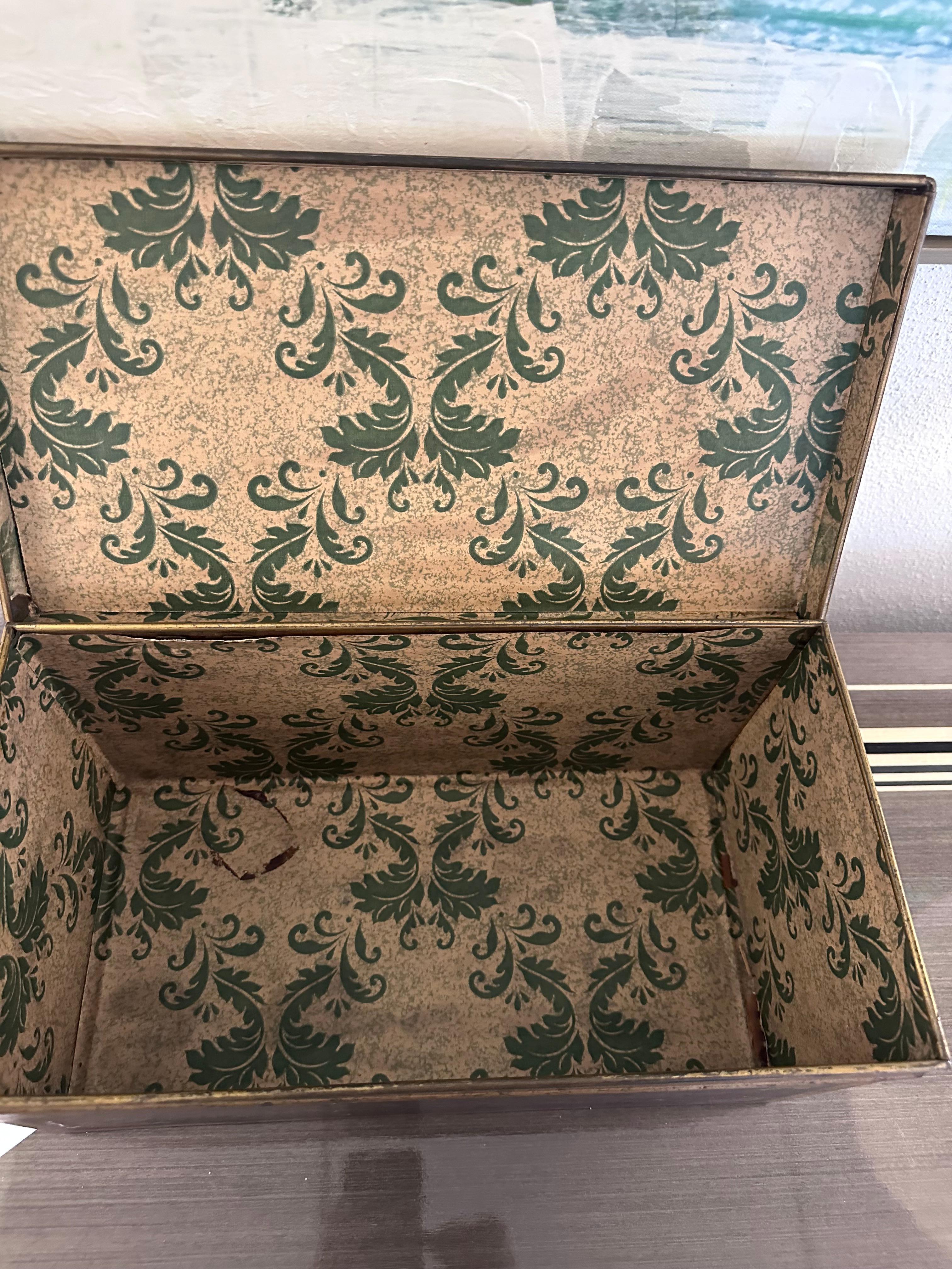 Es handelt sich um eine Aufbewahrungsbox aus Metall im Vintage-Stil, die wahrscheinlich für den Haushalt oder das Büro bestimmt war und sowohl dekorative als auch funktionale Eigenschaften aufweist.  Die Schachtel ist aus Metall, möglicherweise aus