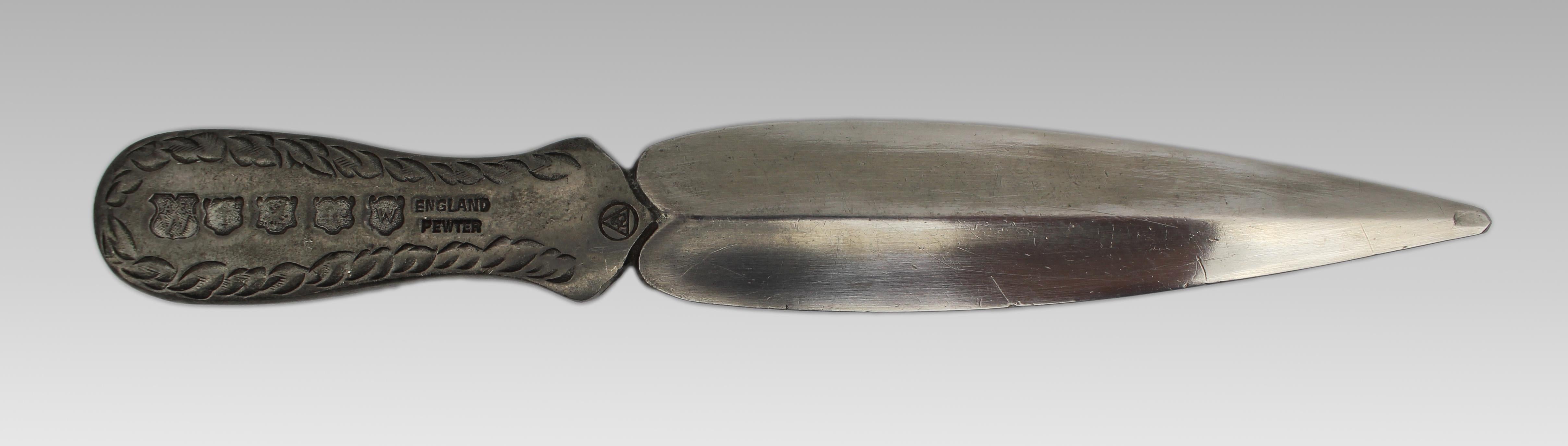 Decorative Mid-20th Century English Pewter Letter Opener
England, circa 1950s
Pewter

A finely cast English letter opener or paper knife, crafted in pewter with a decorative handle featuring mock heraldic hallmarks and foliate borders. The reverse
