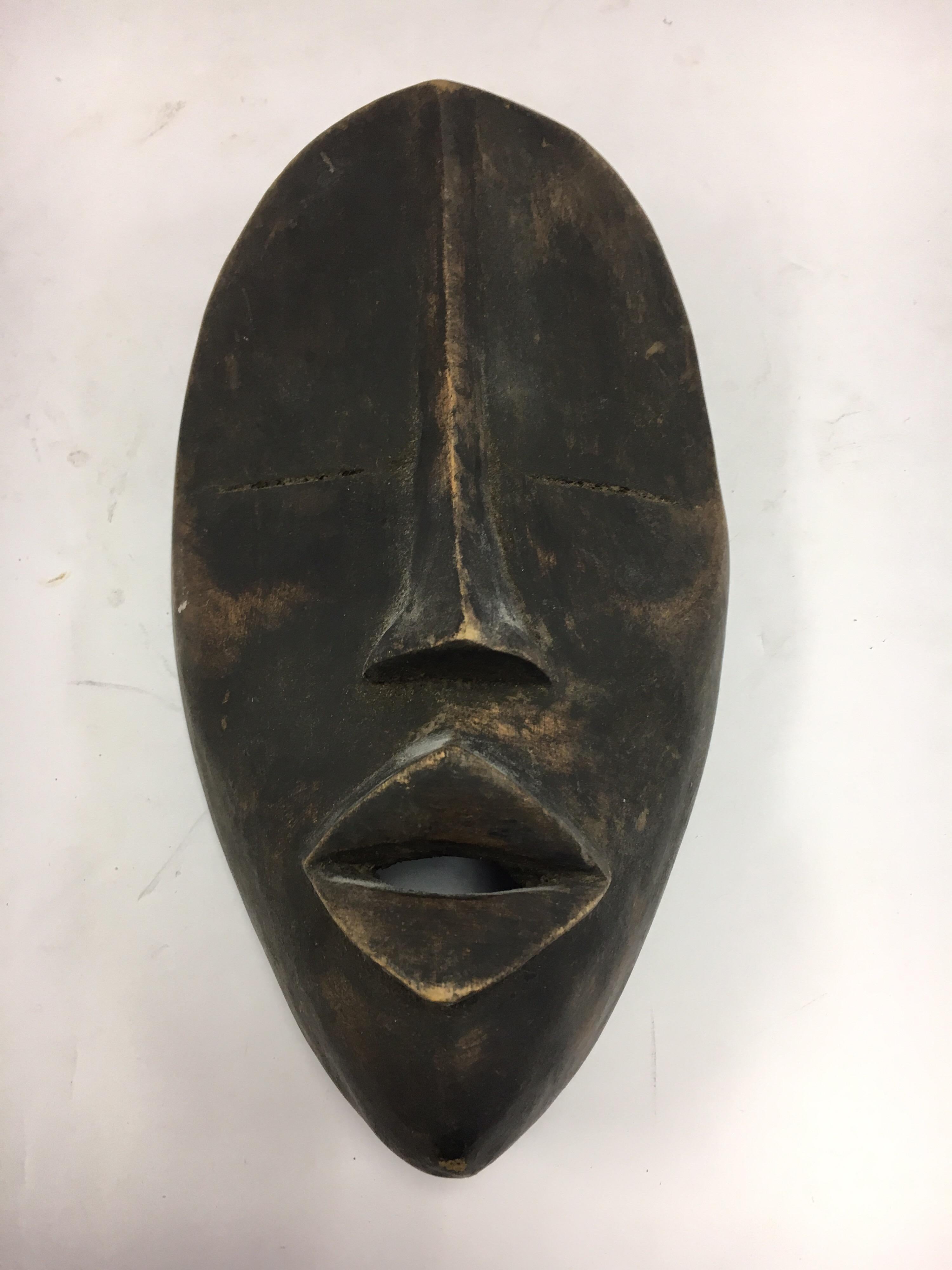 Coveted decorative African hand-carved wood mask with graphic elements, circa 1960s
This is a decorative item from the 1960s, it was made for export, it is not an antique tribal mask.
It was made by a master carver from a single piece of wood and