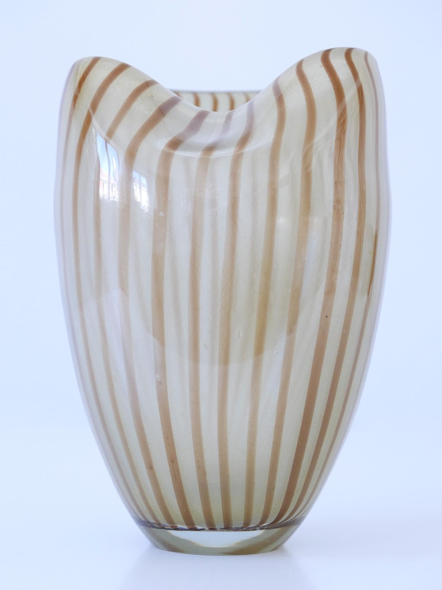 Elegant and highly decorative Mid Century Modern Murano Glass vase with stripes. Made in Italy, 1960s.

Executed in thick hell brown and beige colored Murano-Glass.

Dimensions:
H 9.06 in. (23 cm)
Dm 6.3 in. (16 cm)

Weight: ca. 2.5