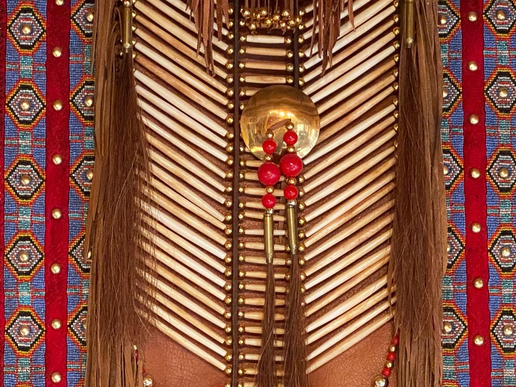This is in the style of a Native American warrior's ceremonial shirt.  Although the exact creator is not know, it was skillfully created by a Native American Indian artist of the Tigua Tribe, Texas. 
Handcrafted with real elk or deer skin leather