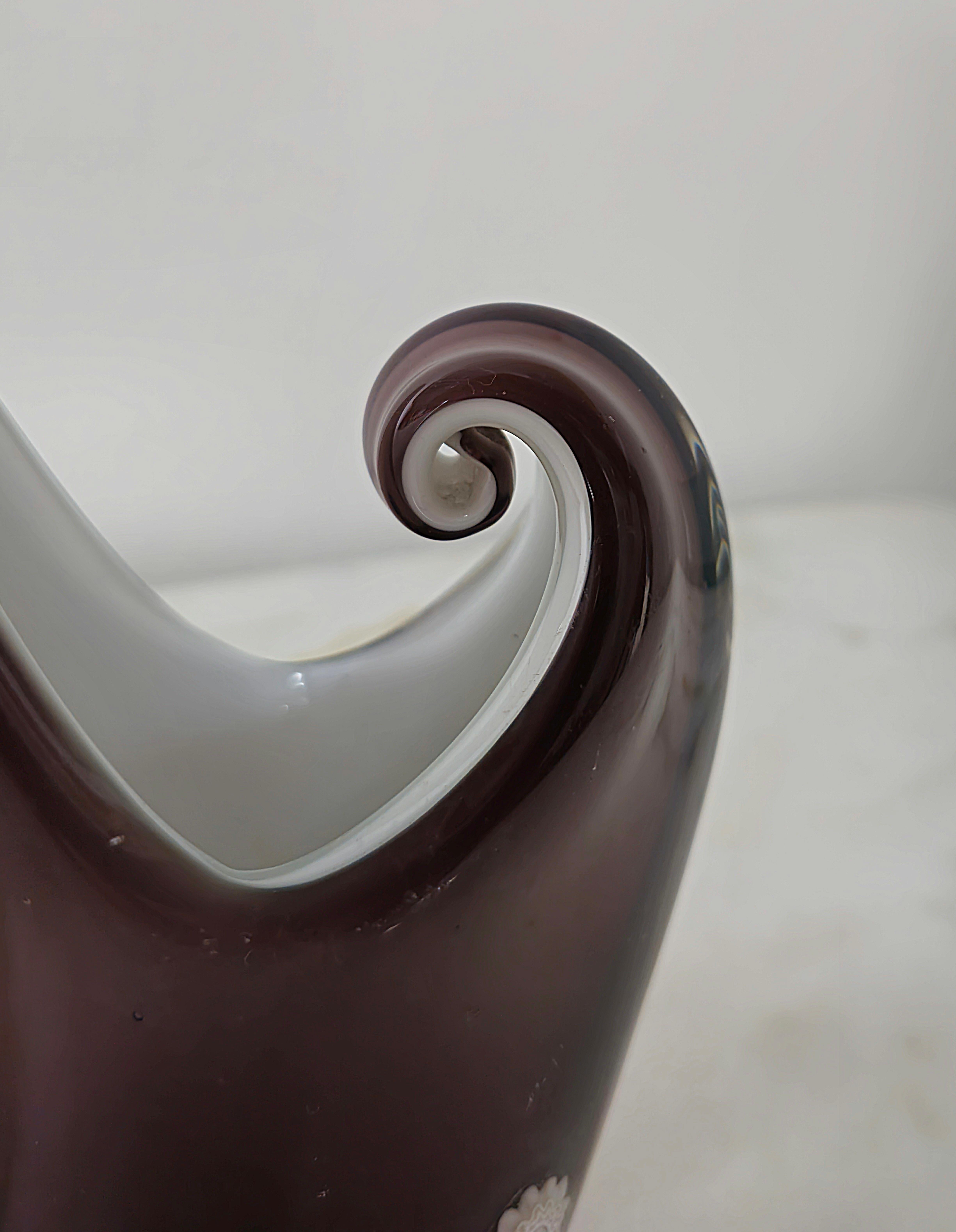 Vase/objet décoratif produit en Italie dans les années 1970 et attribué à la célèbre entreprise de Murano La murrina.
Le vase aux formes particulières a été réalisé en verre de Murano dans des tons d'aubergine, tandis que l'intérieur est dans des