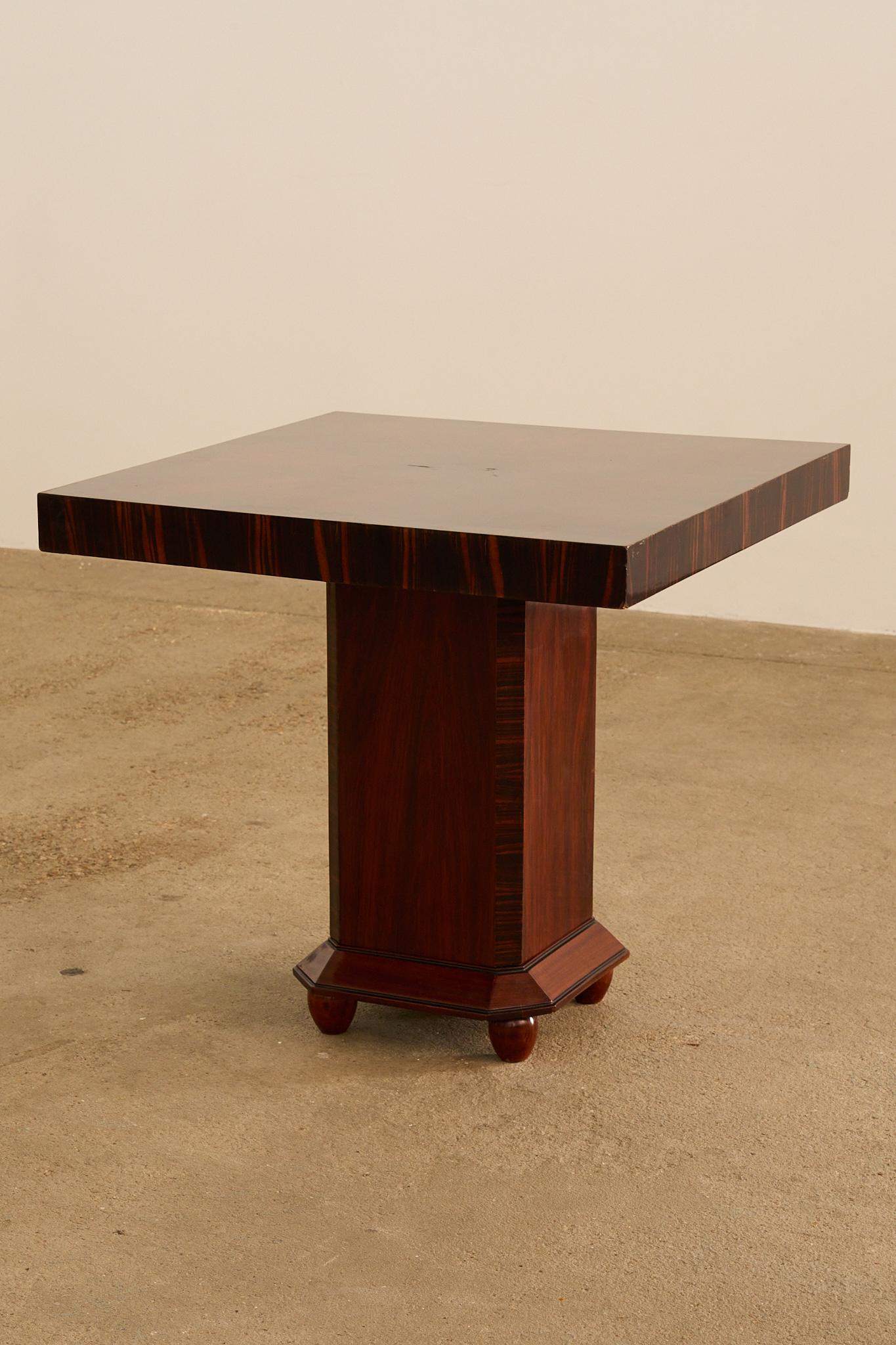 Quadratischer Art Deco Beistelltisch aus Makassar-Ebenholzfurnier, Frankreich, 1930er Jahre. Der Tisch hat eine kühne geometrische Silhouette mit einer dicken quadratischen Platte, die auf einem zentralen Sockel mit achteckigem Sockel und