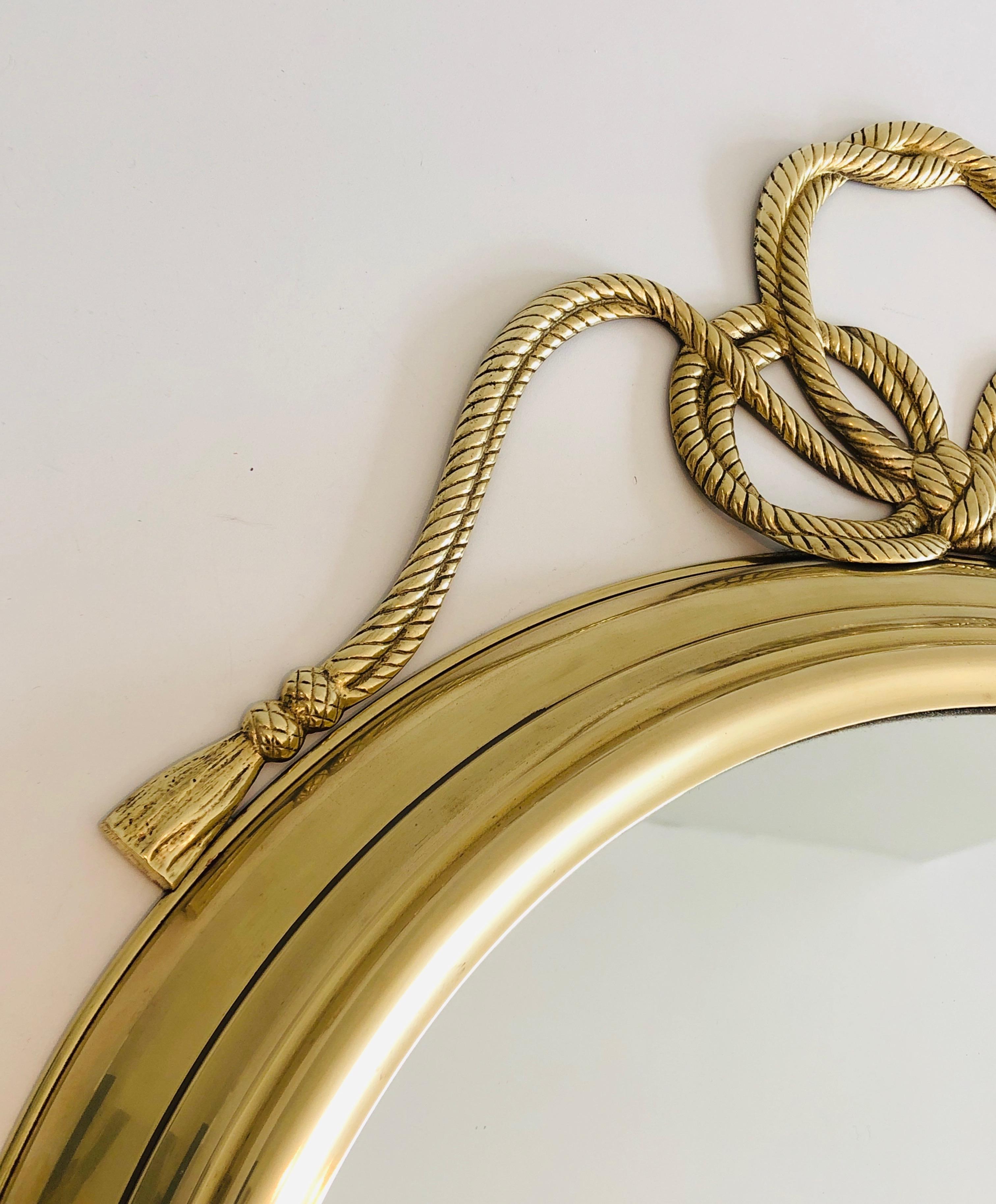 French Decorative Oval Brass Mirror with Large Noddles on Top